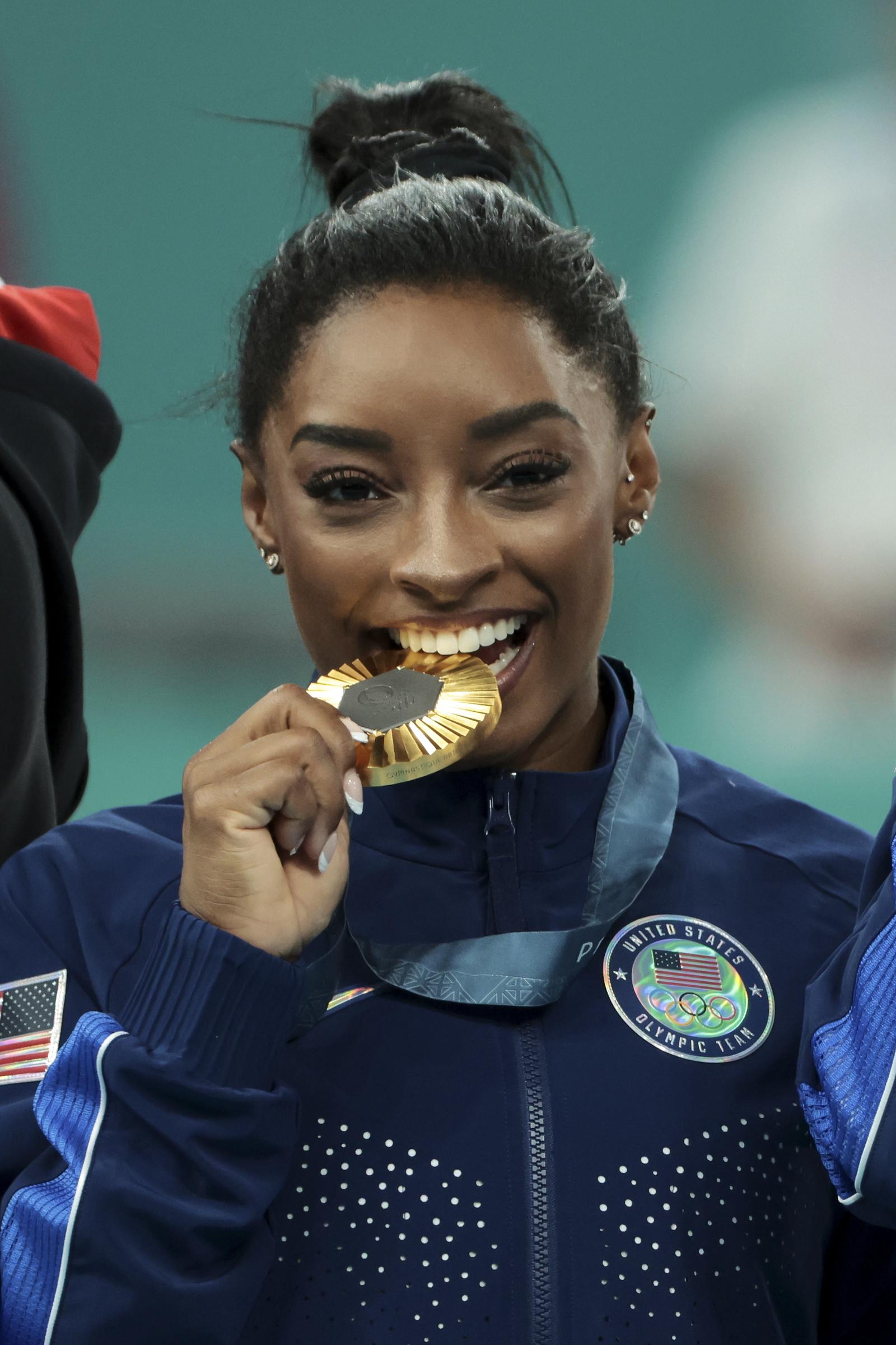 Simone Biles celebrates on the podium during the medal ceremony for the Artistic Gymnastics Womens Team Final on day four of the Olympic Games Paris 2024, at Bercy Arena on July 30, 2024 in Paris, France. | Source: Getty Images