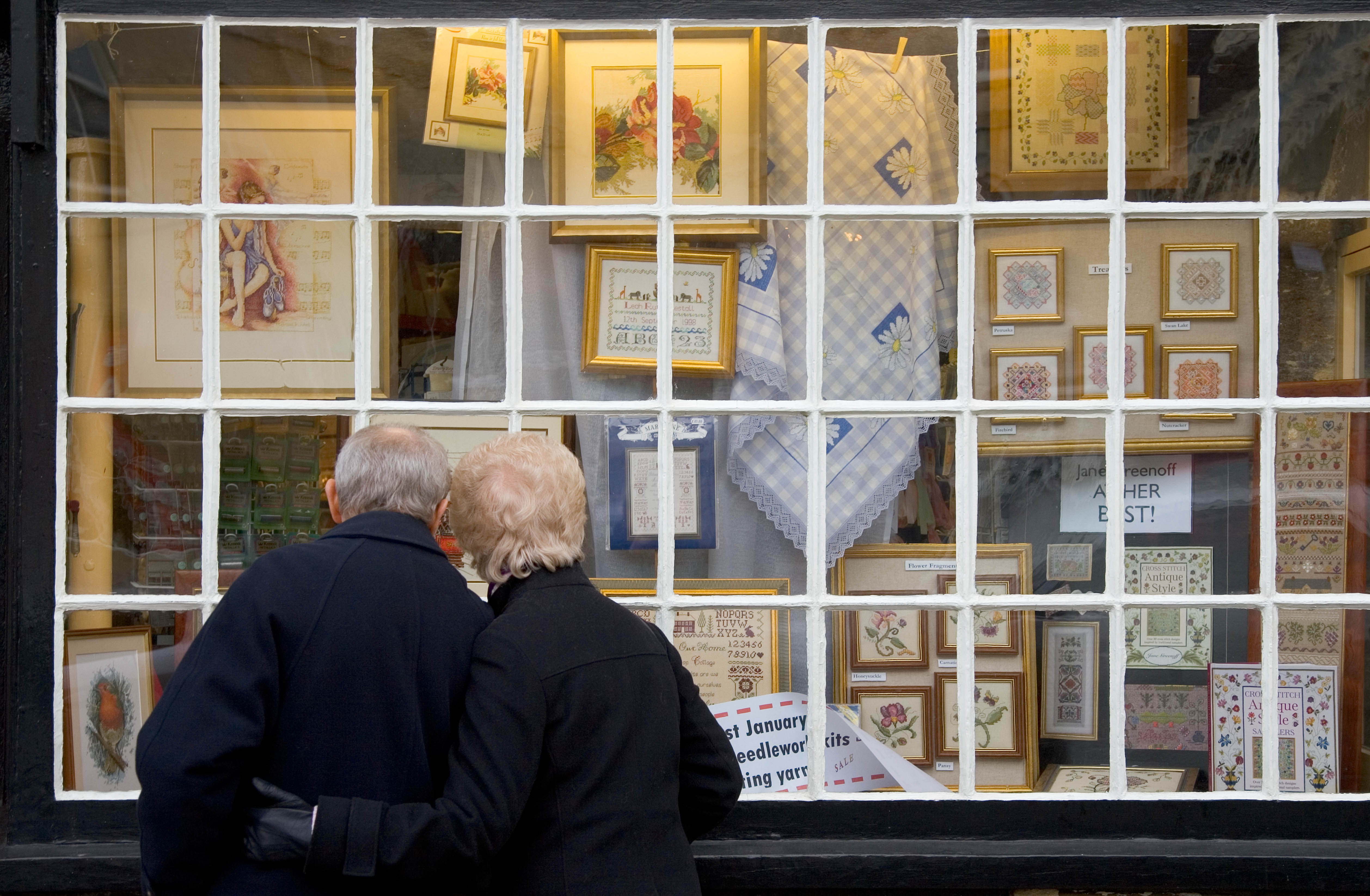 Elderly couple look in the window of a haberdashery shop | Photo : Getty Images