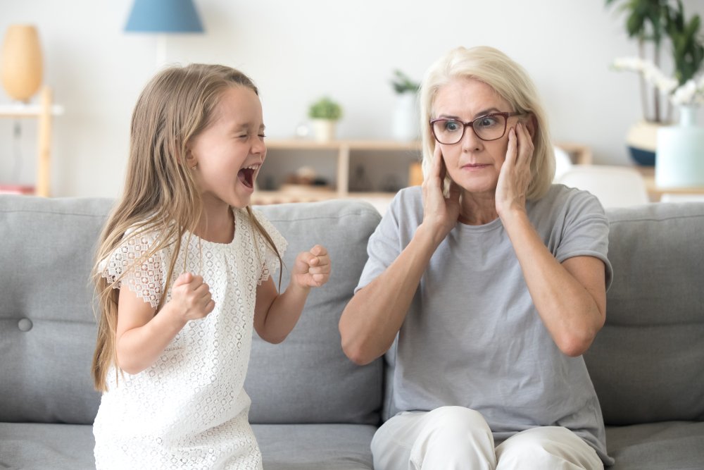 Un enfant qui crie dans les oreilles de sa mère. | Photo : Shutterstock