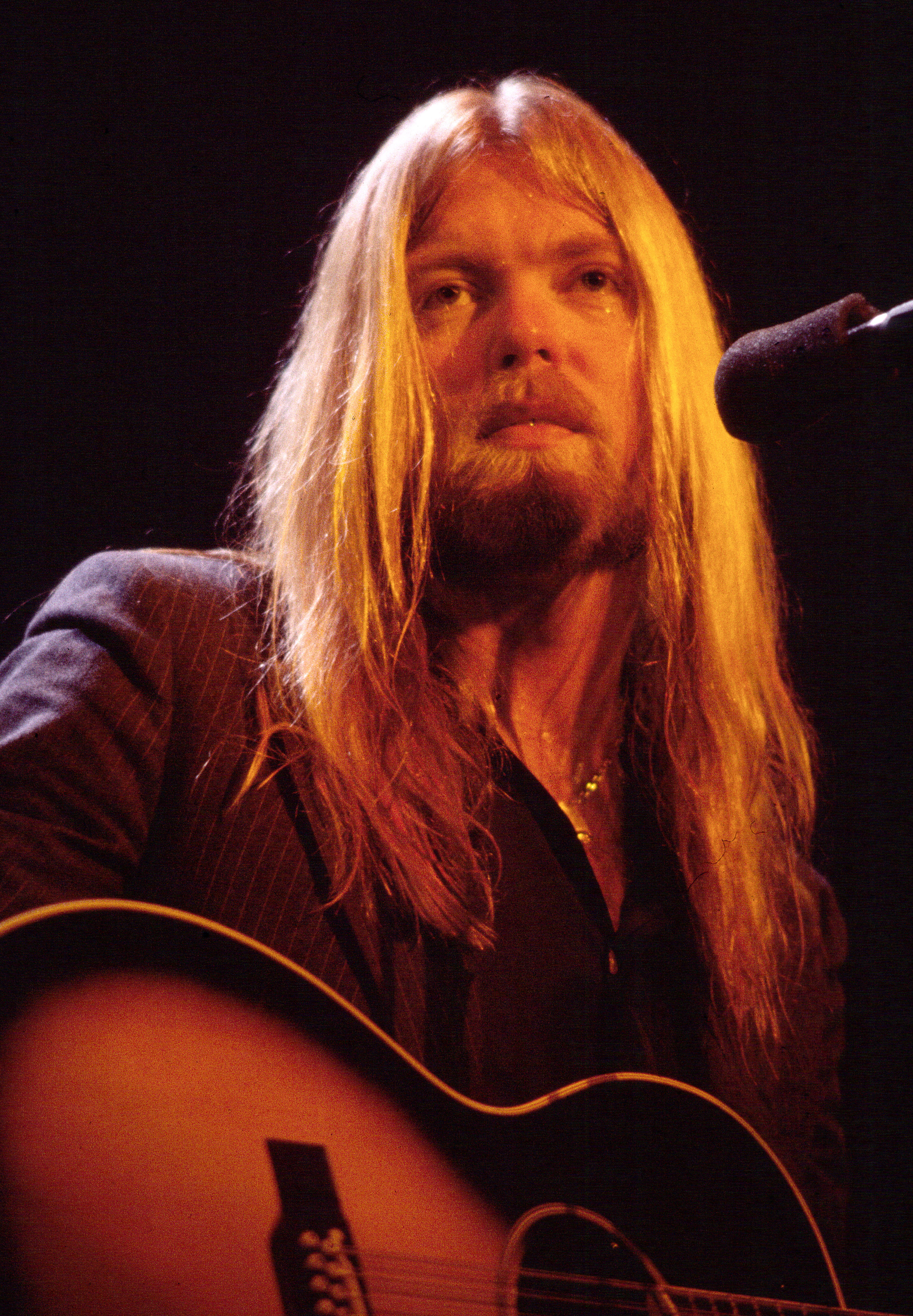 Gregg Allman plays guitar as he performs onstage at the Capitol Theatre in Passaic, New Jersey, on December 16, 1981. | Source: Getty Images
