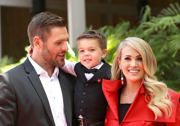 Carrie Underwood with her husband, and their son together at a  ceremony | Photo: Getty Images