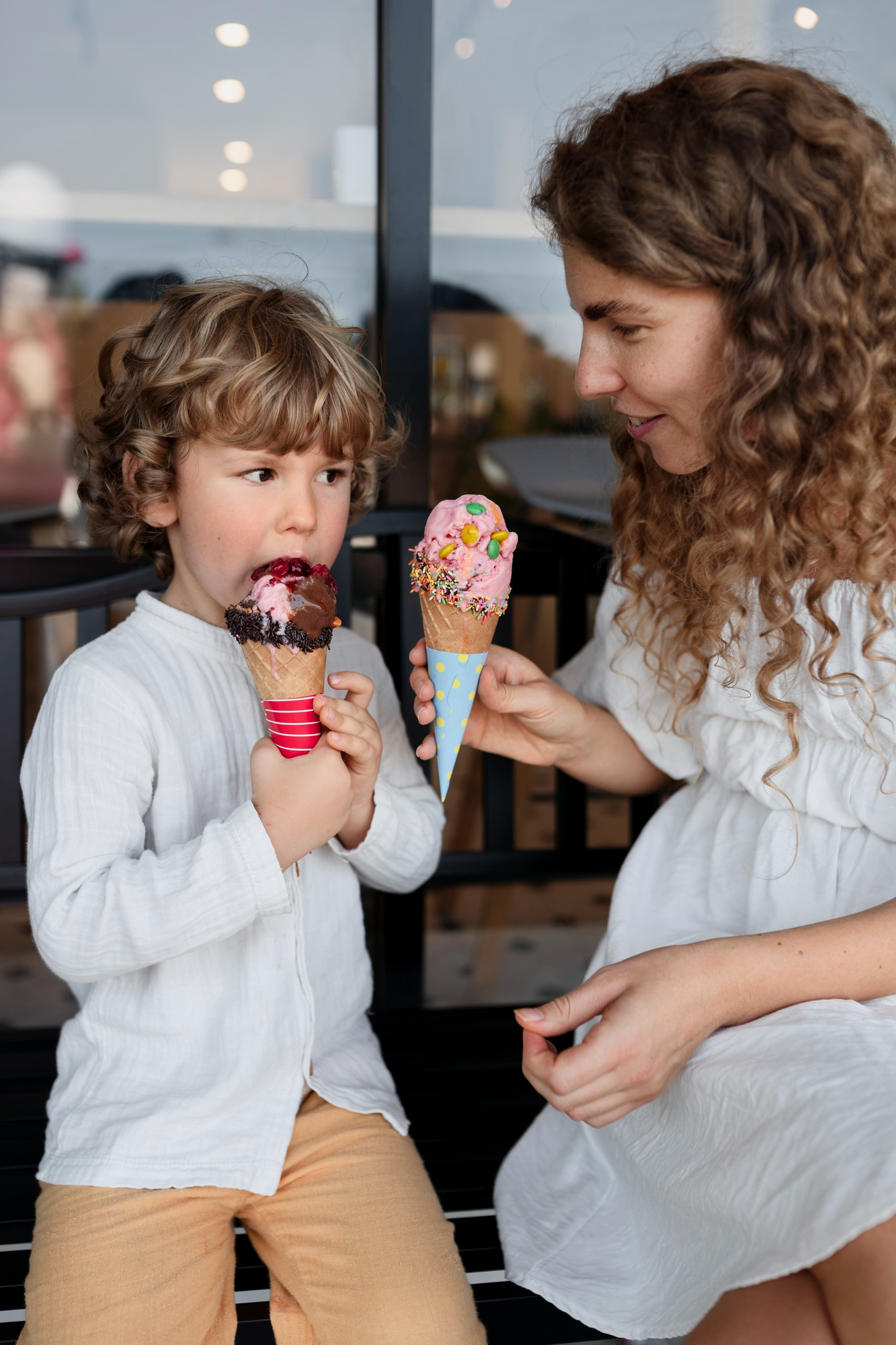 A woman giving ice cream cones to a little boy | Source: Freepik
