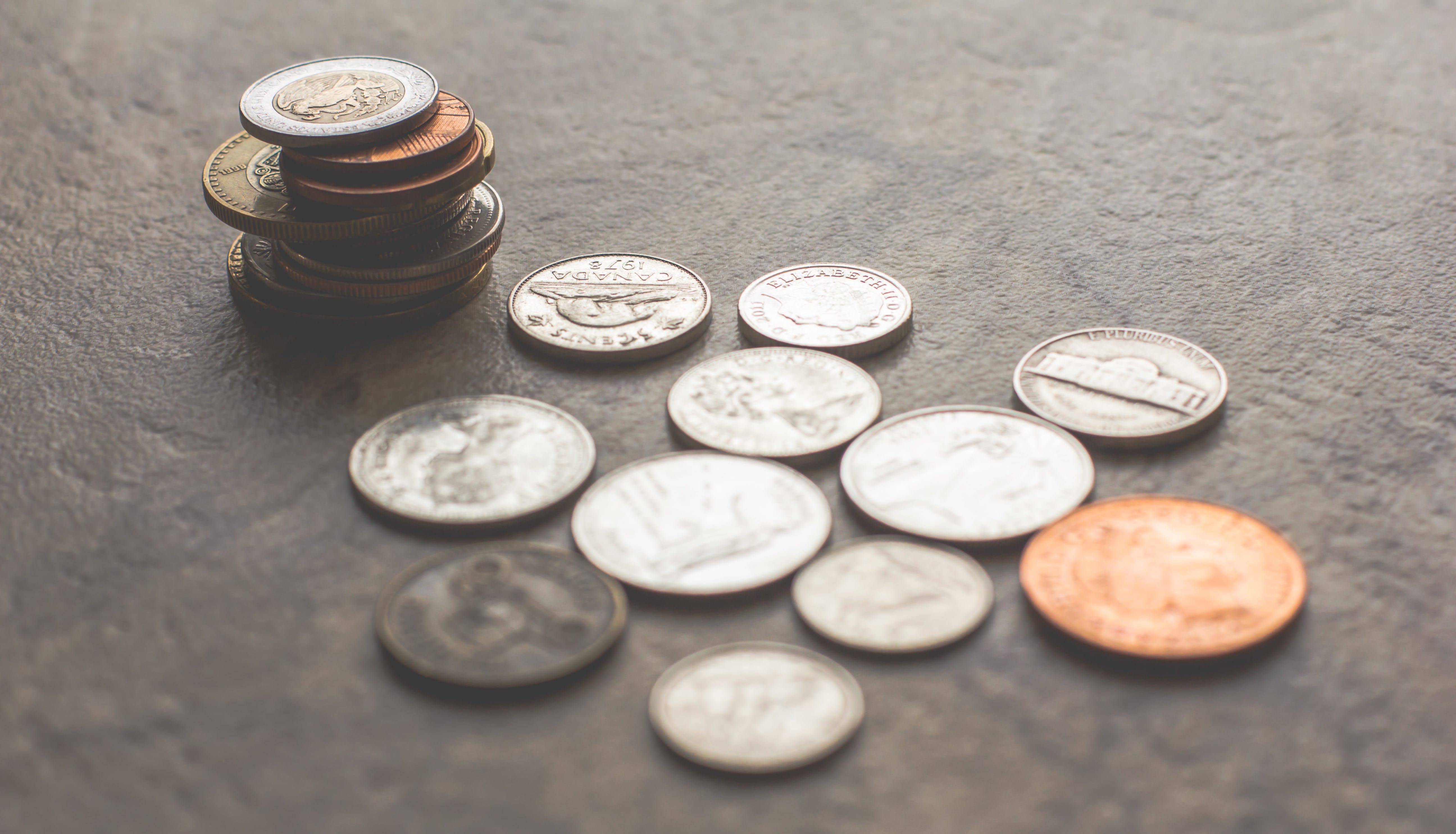 Gold and silver coins on a grey surface. | Source: Pexels
