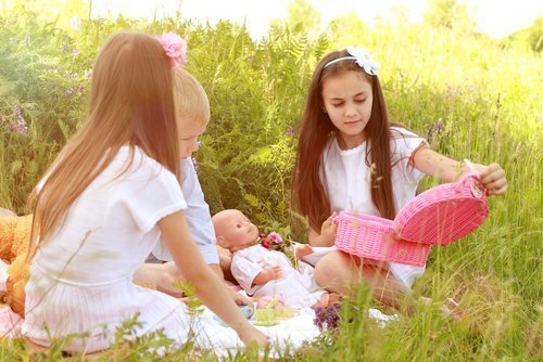 Girls playing with their dolls outdoors. | Source: Shutterstock.