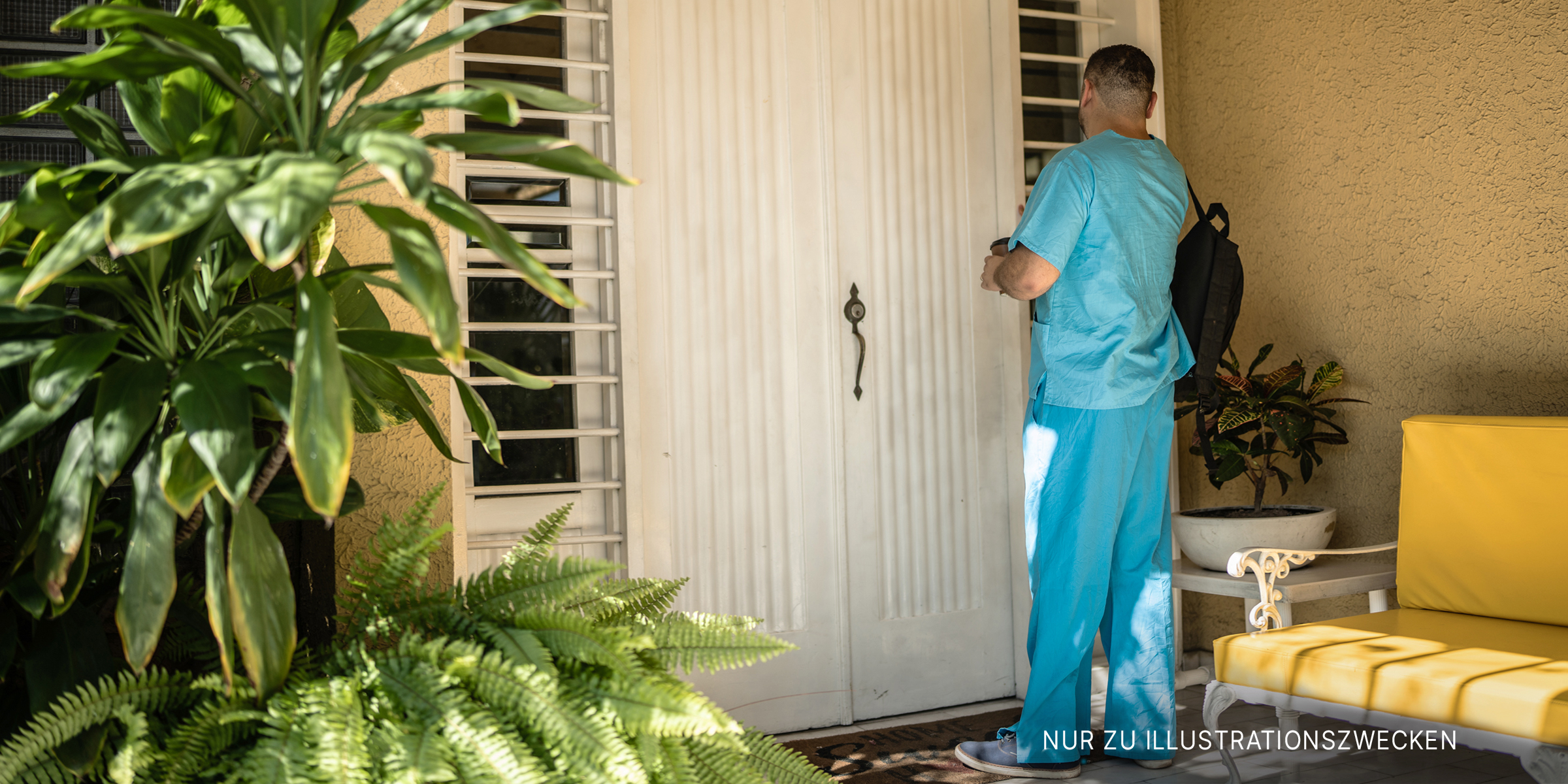 Mann im Kittel wartet an der Haustür | Quelle: Getty Images