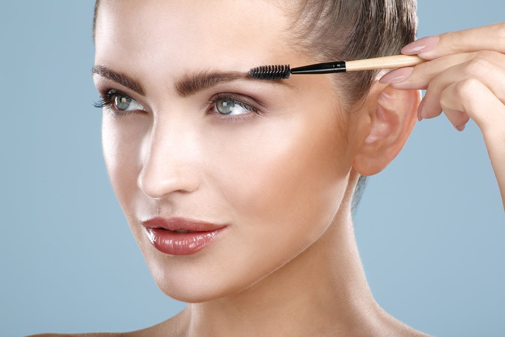 Mujer cepillándose las cejas. | Foto: Shutterstock