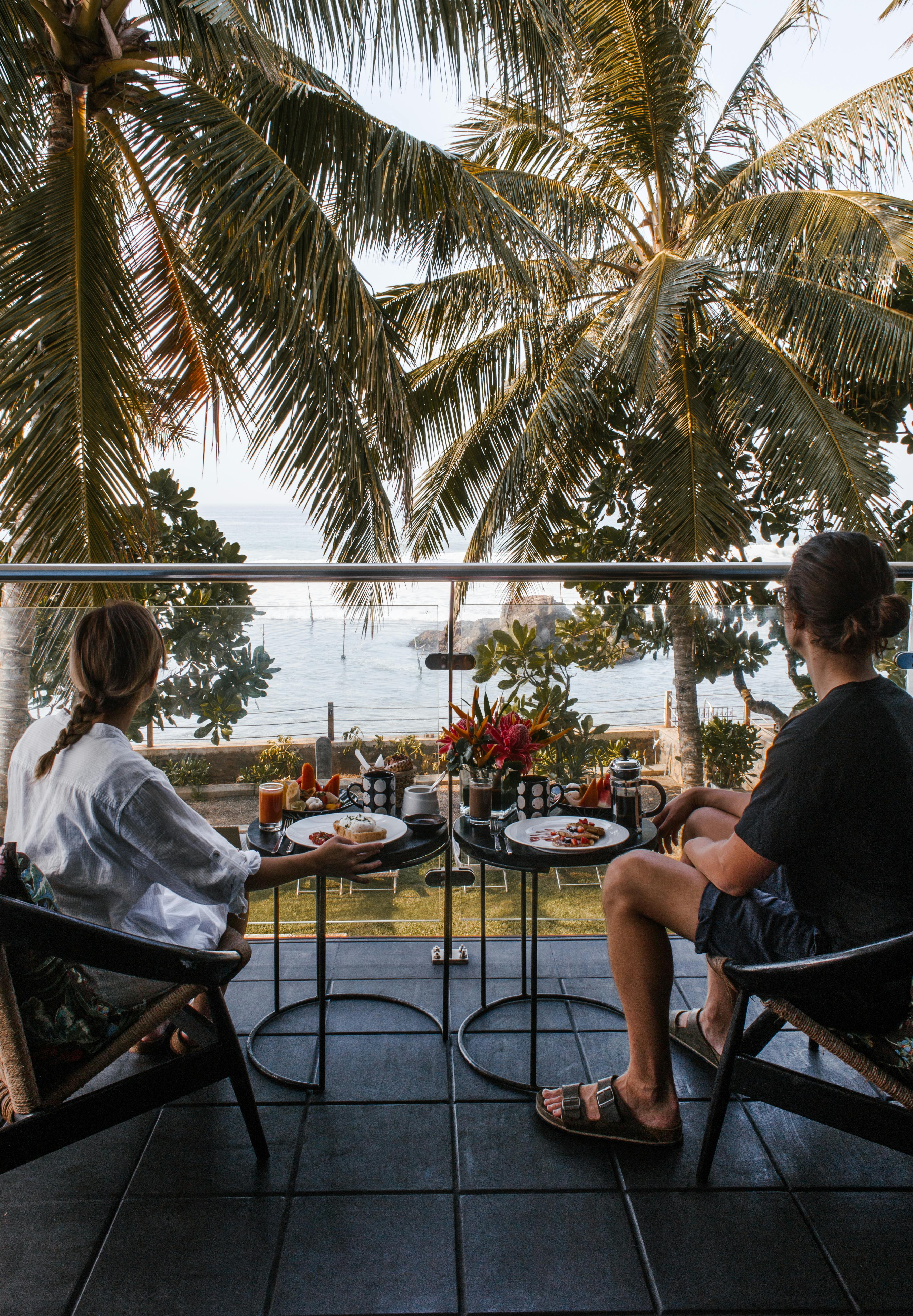 A man and woman enjoying the view and a meal during a romantic getaway | Source: Pexels