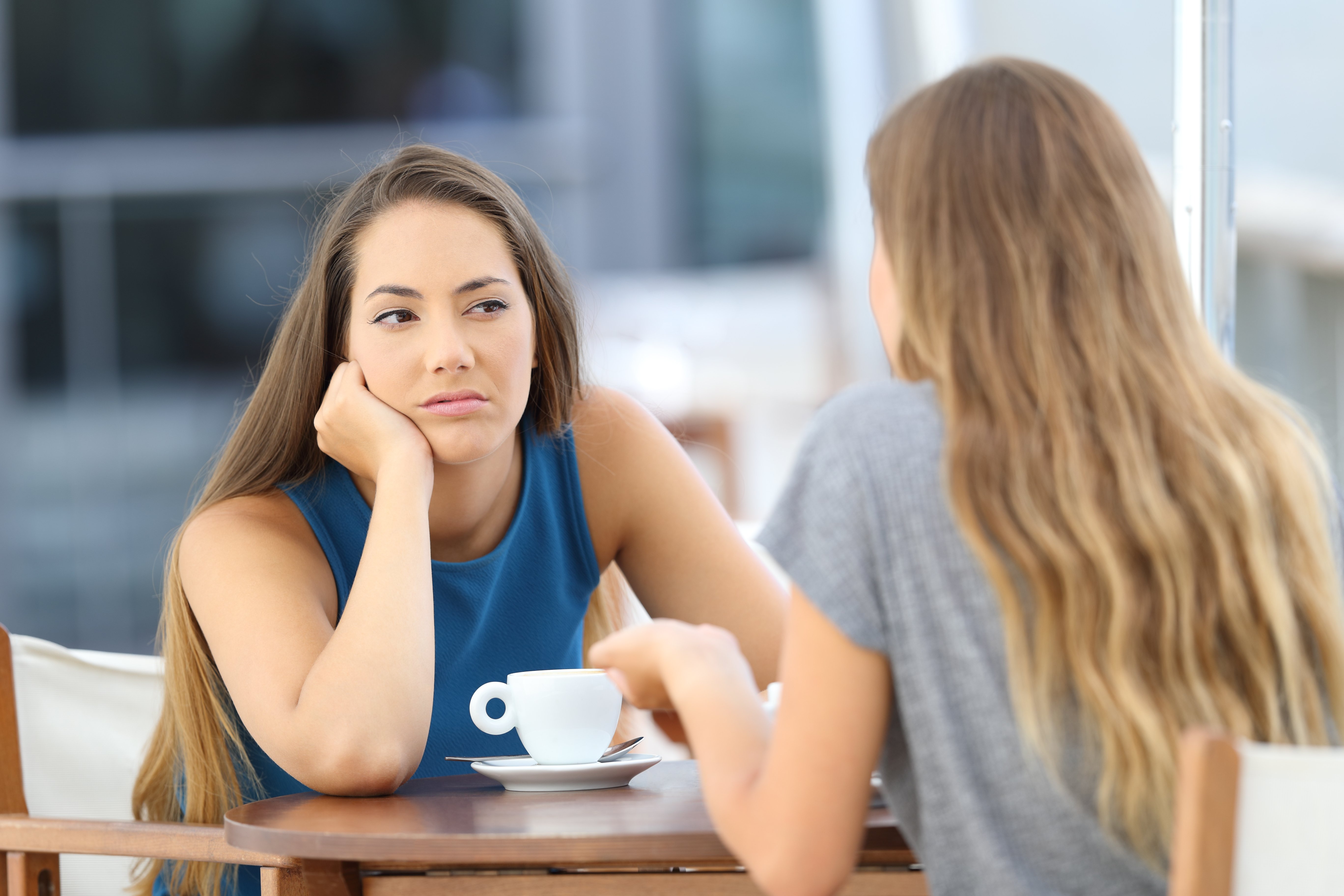 Mujer escucha a amiga con mala cara. | Foto: Shutterstock