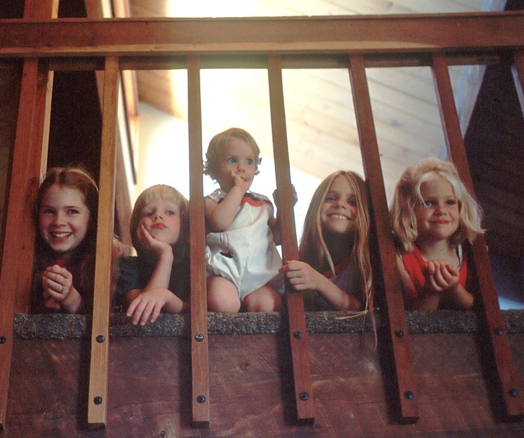 Cinco niños mirando por una escalera. | Foto: Unsplash