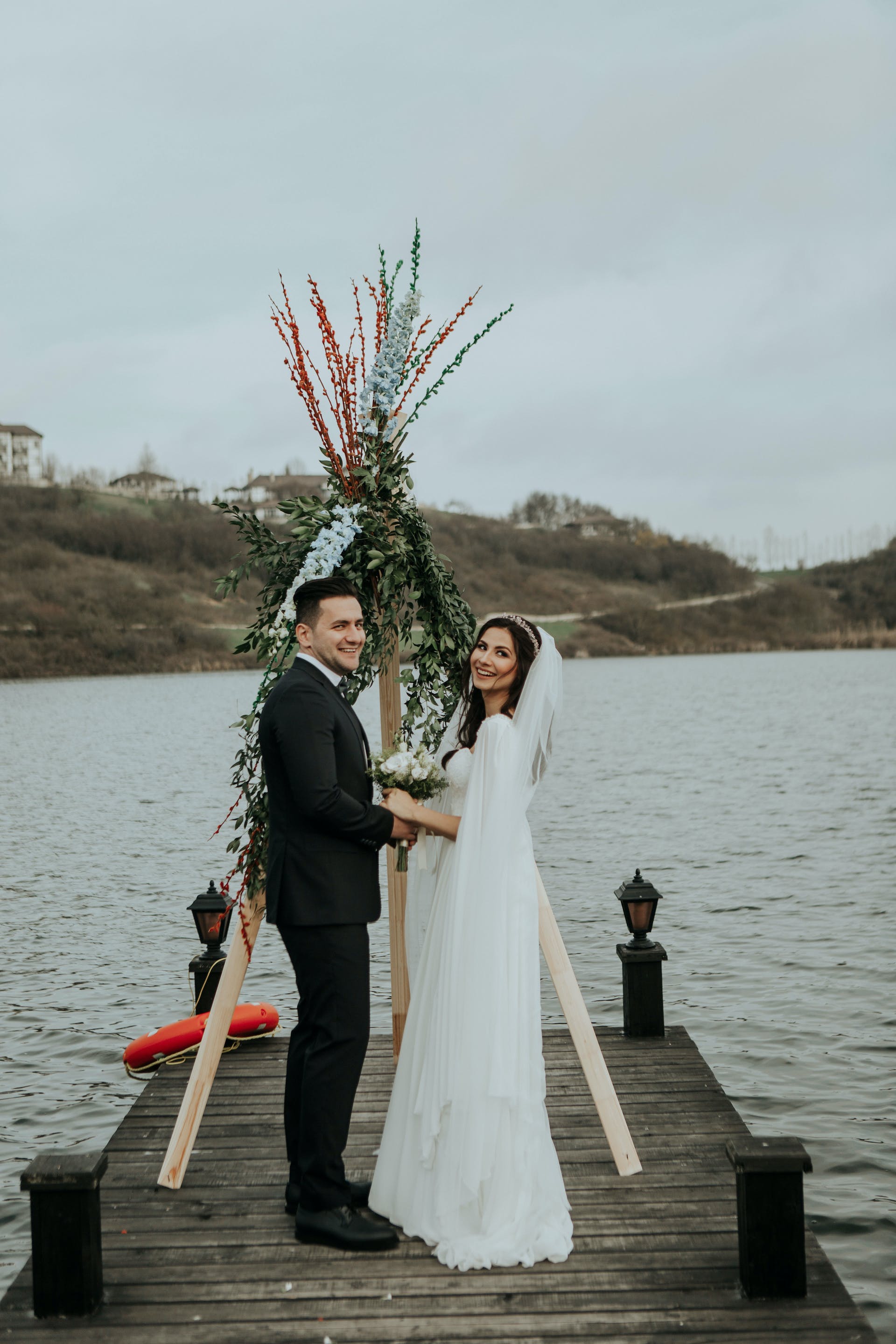 A bride and groom standing on a pier | Source: Pexels