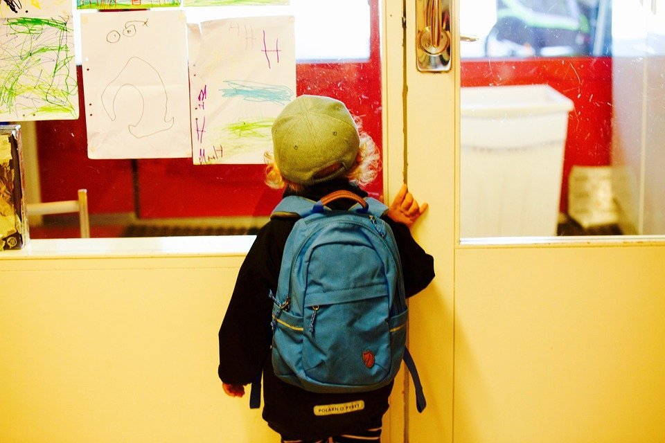 Un niño en la escuela mira a través de una ventana. | Foto: Pixabay