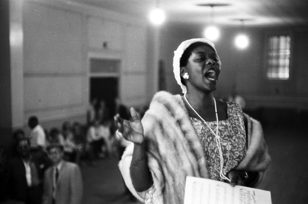  Jazz singer Dinah Washington sings at a church service the weekend of the American Jazz Festival (later renamed the Newport Jazz Festival) in July 1958  | Photo: Getty Images