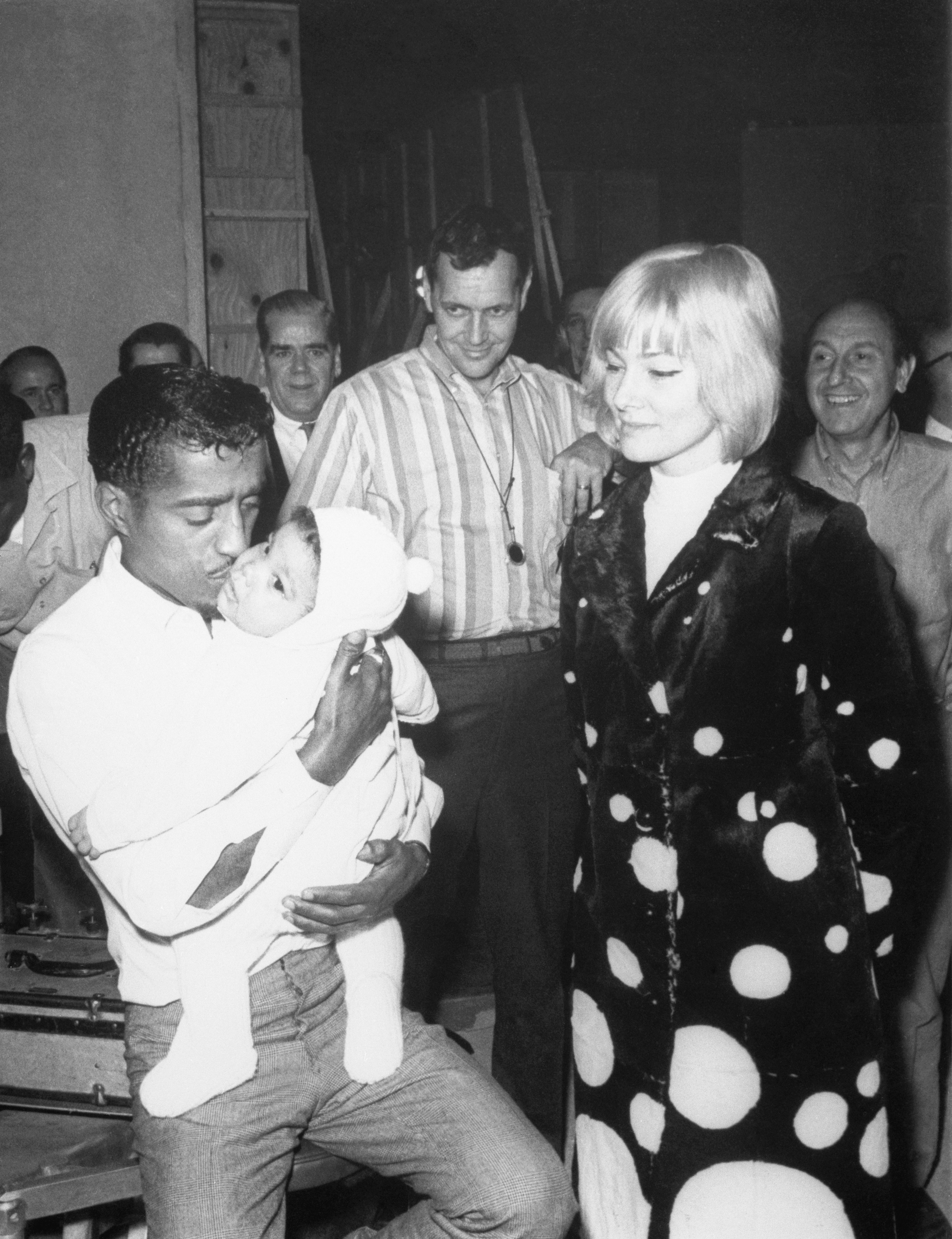 Sammy Davis, Jr. with his wife, May Britt, standing along with crew members of A Man Named Adam. | Source: Getty Images