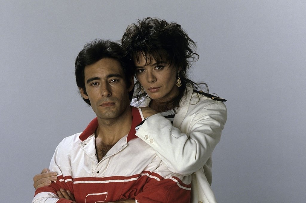Portrait de Gérard LANVIN avec son épouse Jennifer se tenant par la taille posant en studio, août 1985. | Photo : Getty Images