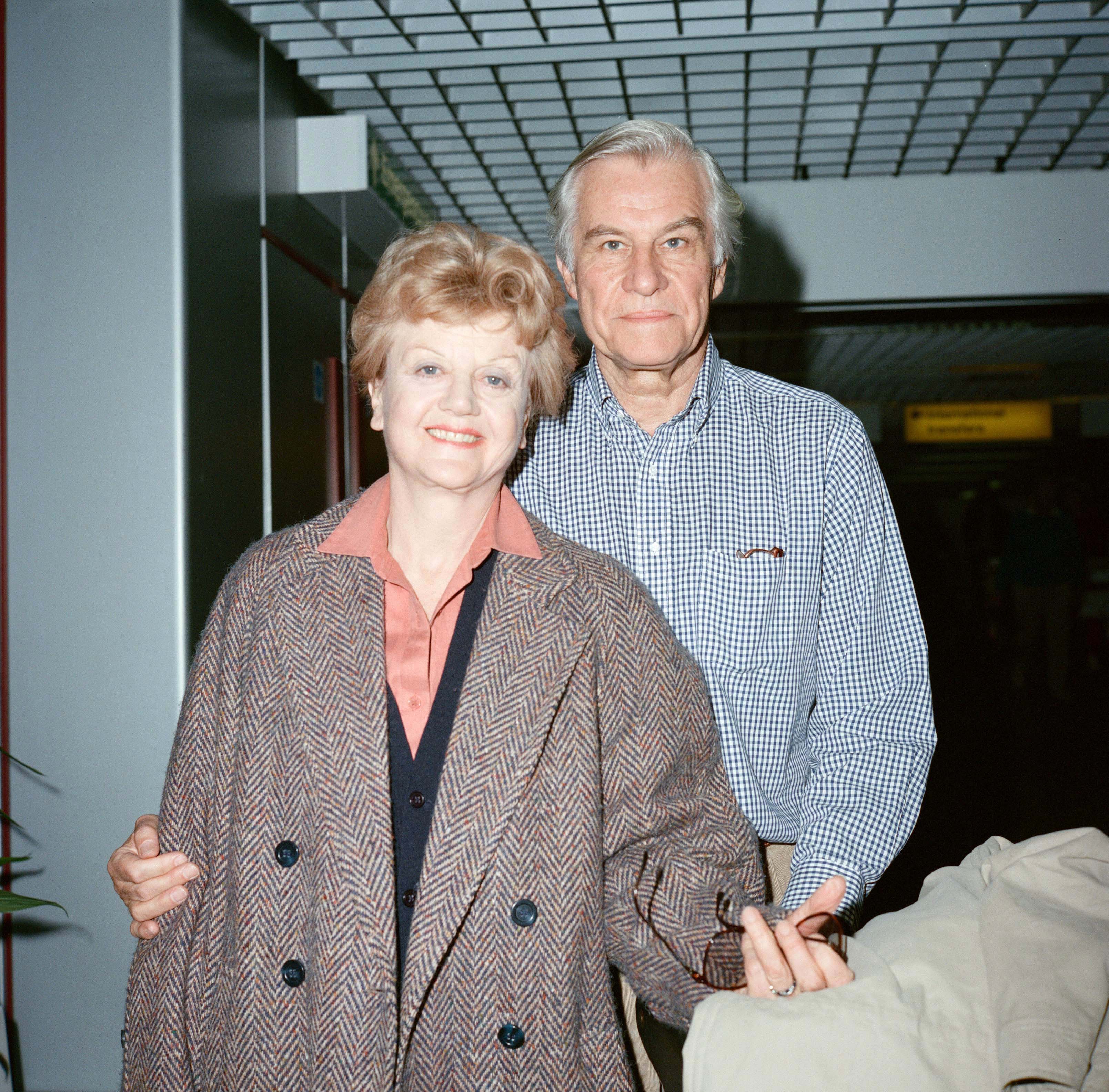 Angela Lansbury and her husband Peter Shaw photographed at London airport on March 13, 1990 in London, United Kingdom ┃Source: Getty Images