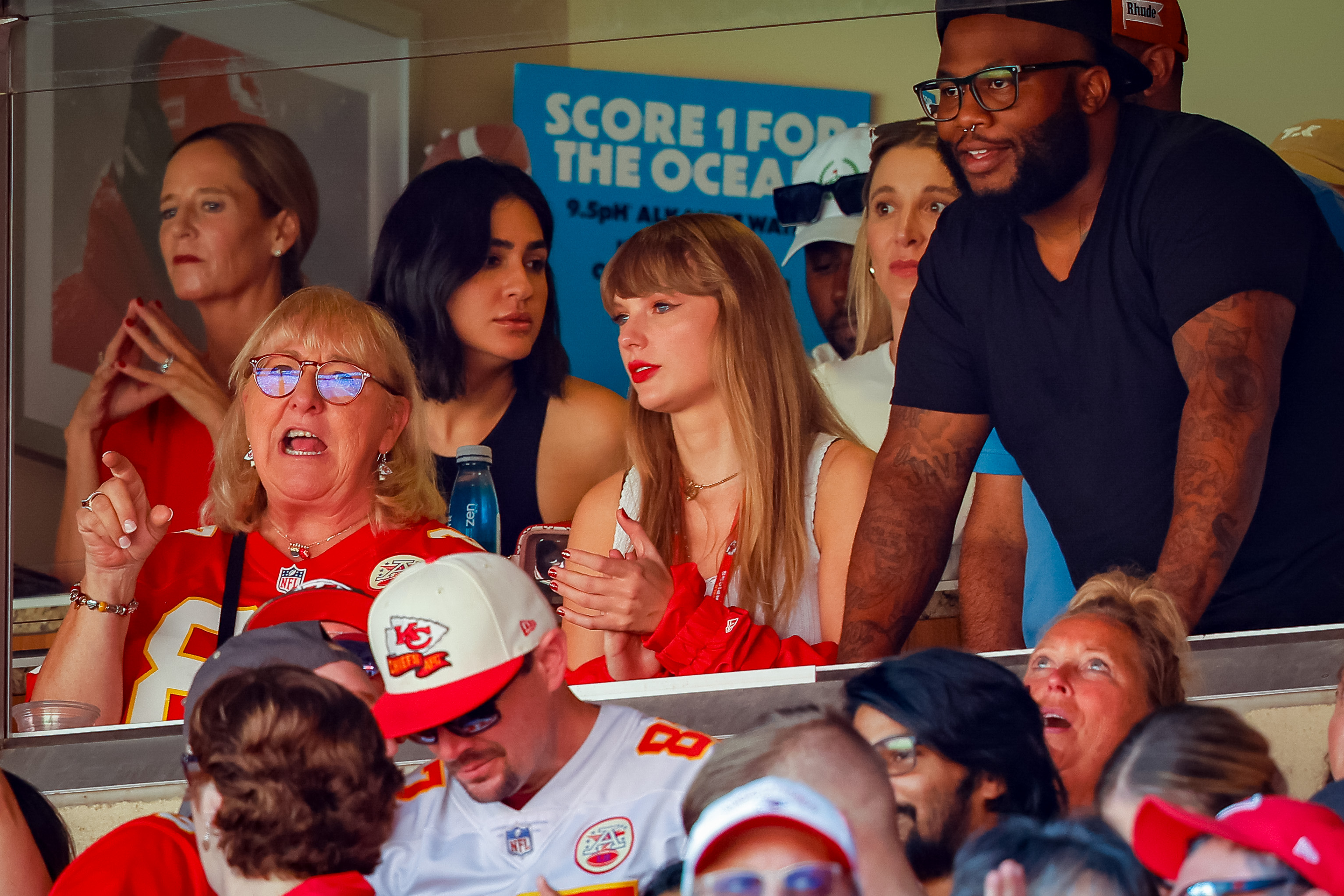Taylor Swift, dressed in a white tank top and red jacket, sits beside Donna Kelce, the mother of Kansas City Chiefs tight end Travis Kelce, who is wearing a red Chiefs jersey, as they watch the regular-season game between the Kansas City Chiefs and the Chicago Bears at GEHA Field at Arrowhead Stadium on September 24, 2023, in Missouri.