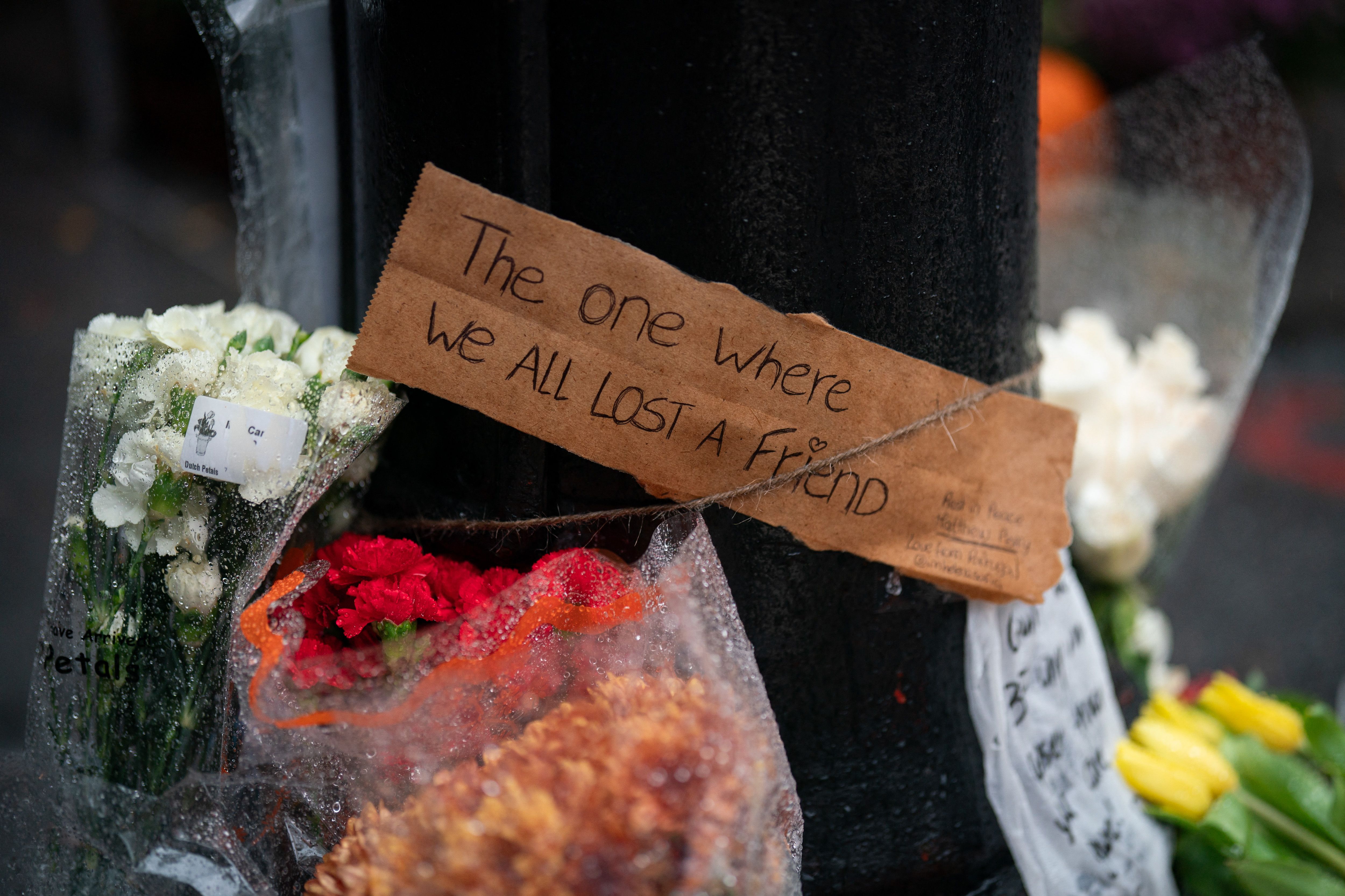 Floral tributes are left for Matthew Perry outside the apartment building, which was used as the exterior shot in the TV show "Friends" in New York on October 29, 2023. | Source: Getty Images