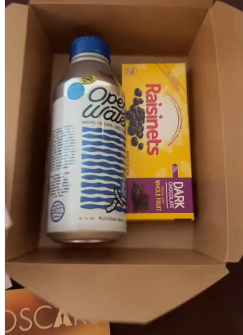 A box of Raisinets appears beside the water, completing the simple, nostalgic trio of theater-style treats. | Source: Instagram/A box of Raisinets appears beside the water, completing the simple, nostalgic trio of theater-style treats. | Source: Instagram/instylemagazine