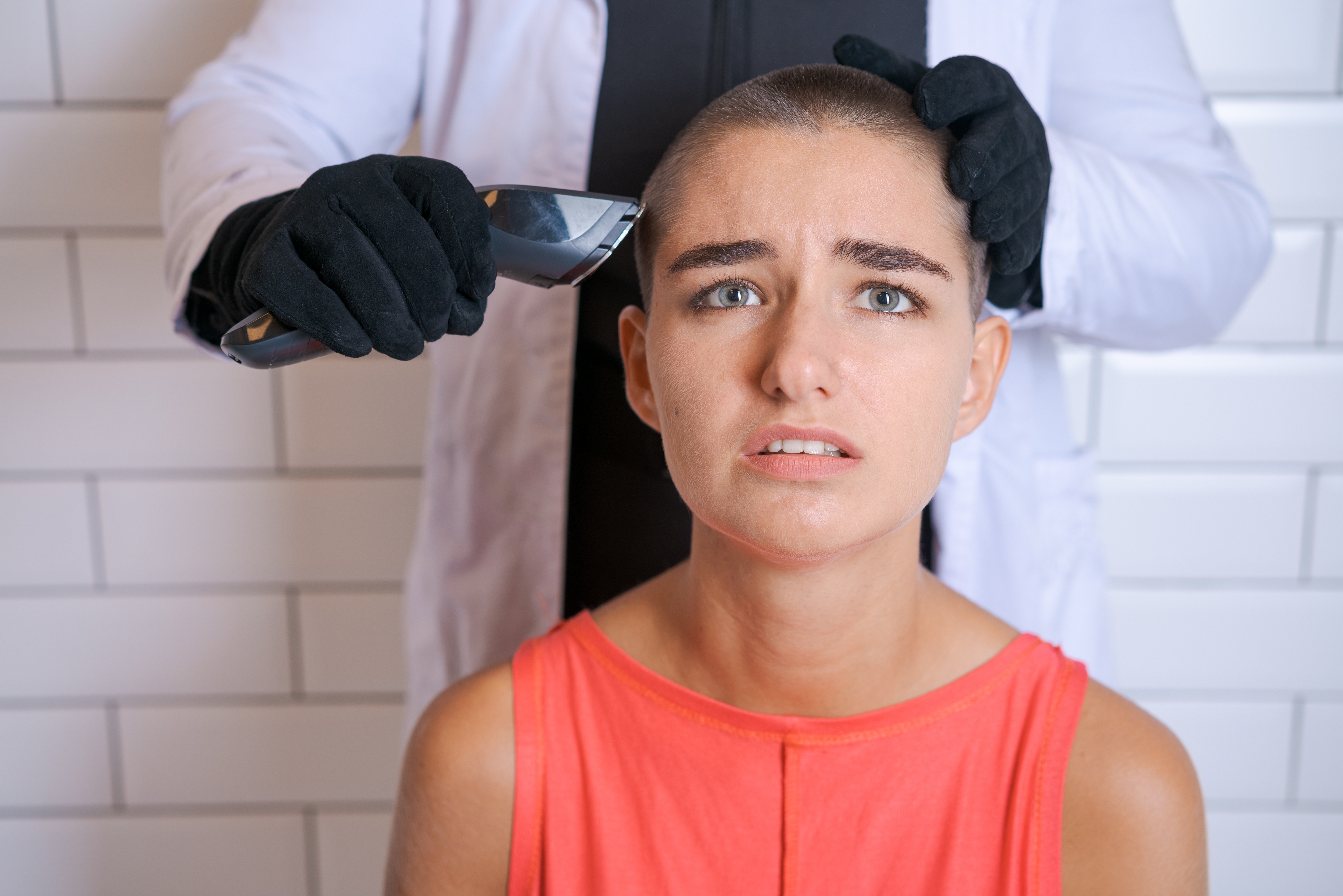Eine Frau, die gezwungen wird, sich die Haare zu rasieren | Quelle: Shutterstock