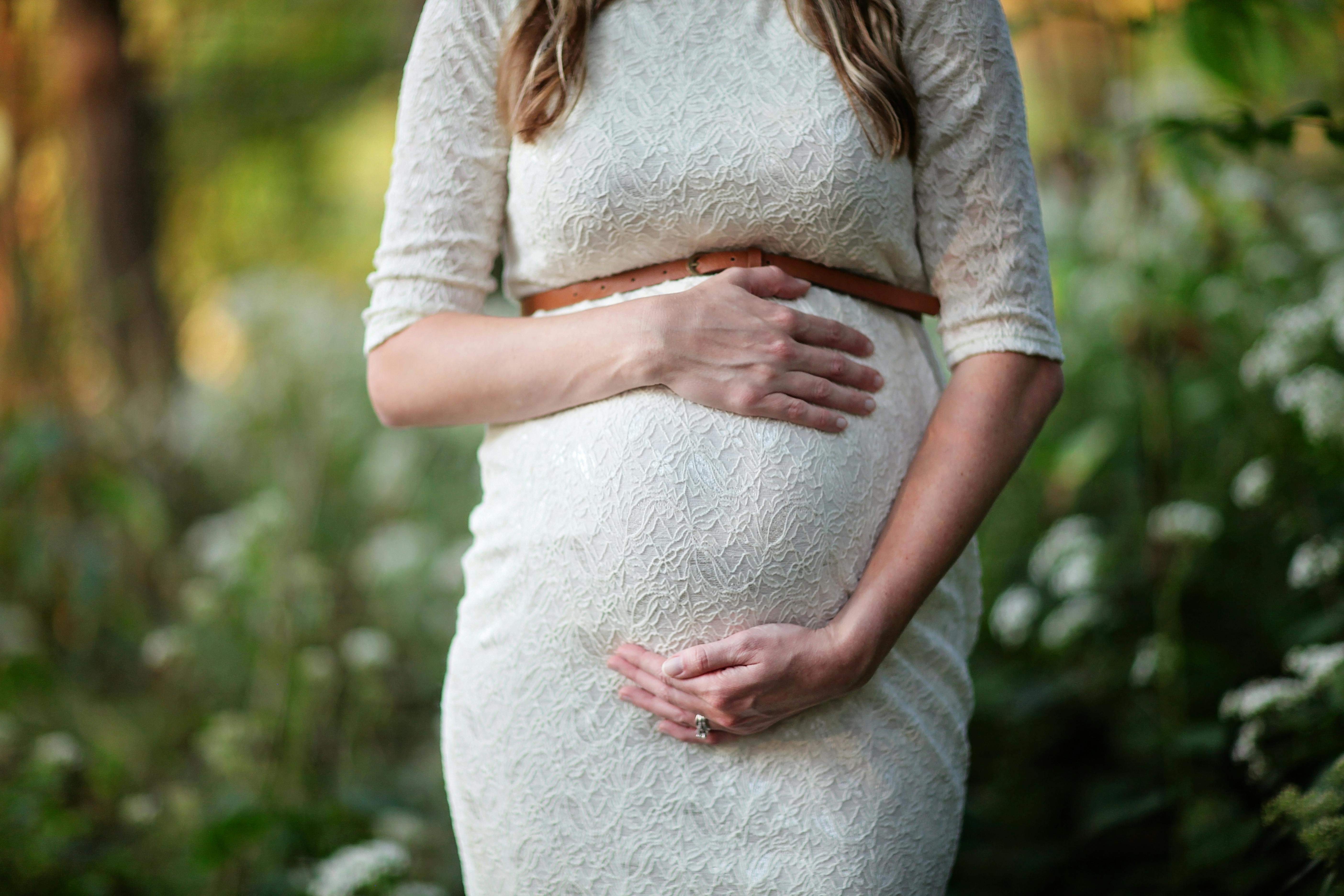 A pregnant woman cradling her baby bump | Source: Pexels