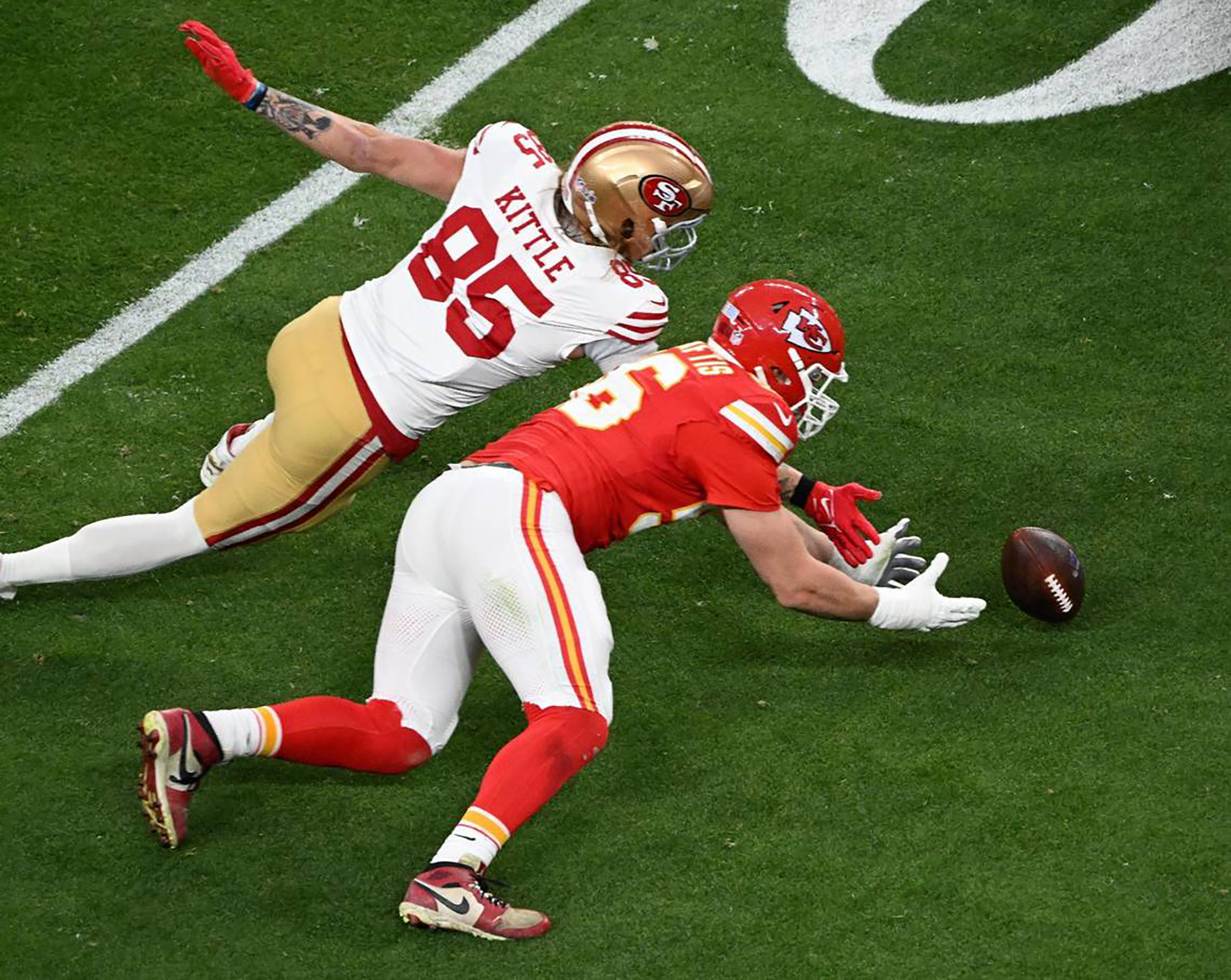 Kansas City Chiefs defensive end George Karlaftis and San Francisco 49ers tight end George Kittle playing during the Super Bowl LVIII in Las Vegas, Nevada on February 11, 2024 | Source: Getty Images