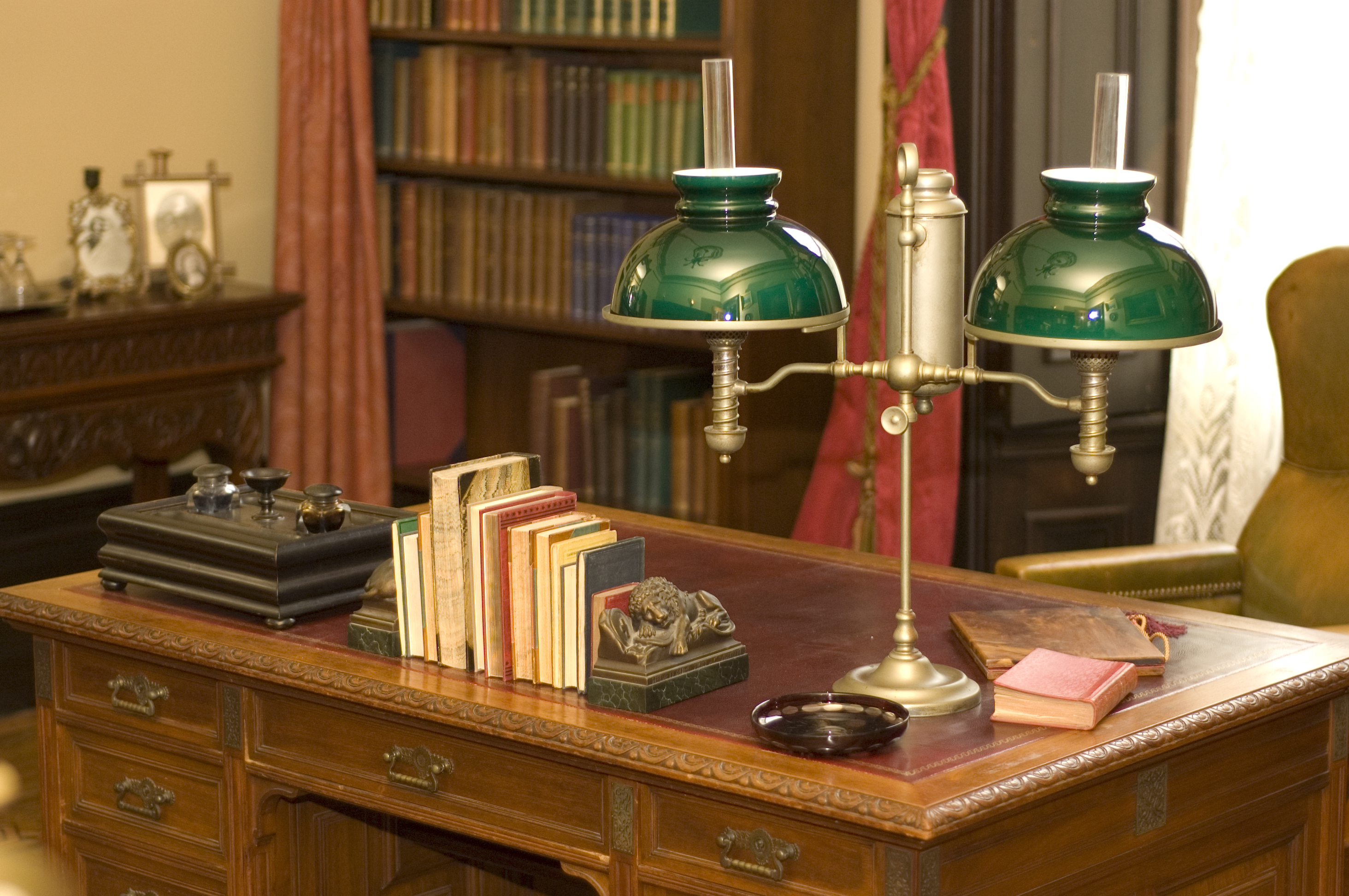 A classic oil lamp and books placed on an antique office desk | Source: Shutterstock