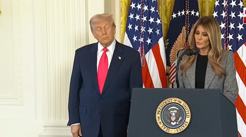 Donald Trump stands next to Melania as she delivers her speech on November 13, 2025 | Source: YouTube/@FoxNews