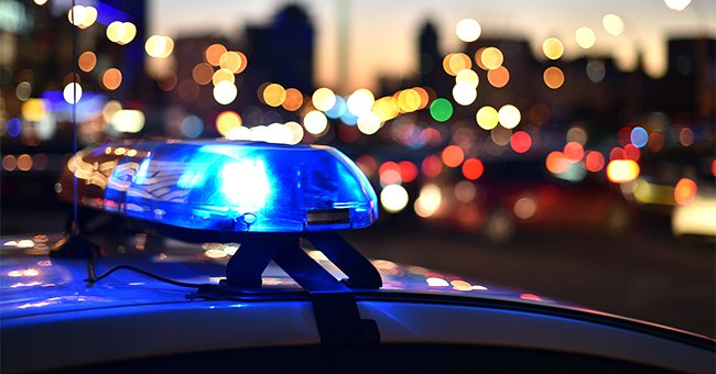A close up of the lights on a police vehicle, and blurry city lights in the background. | Photo: Shutterstock