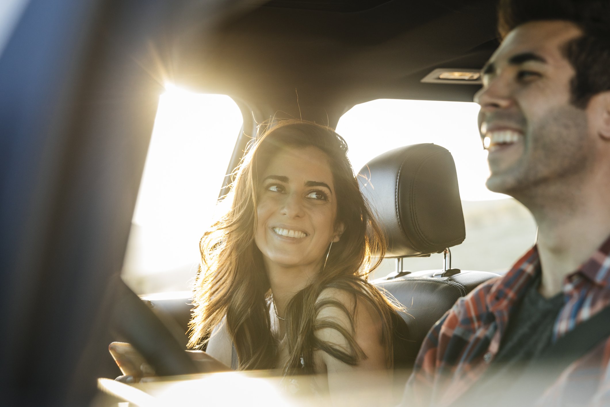 Pareja riendo durante un viaje en carro. | Foto: Getty Images