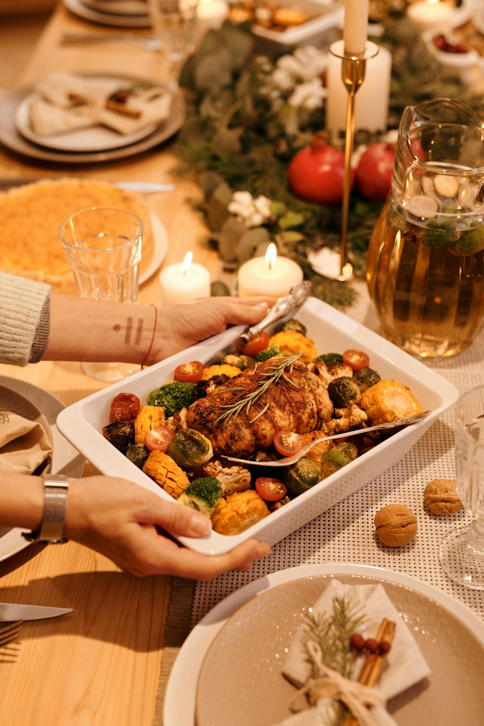 A closeup shot of a person putting food on the table for a family dinner | Source: Pexels