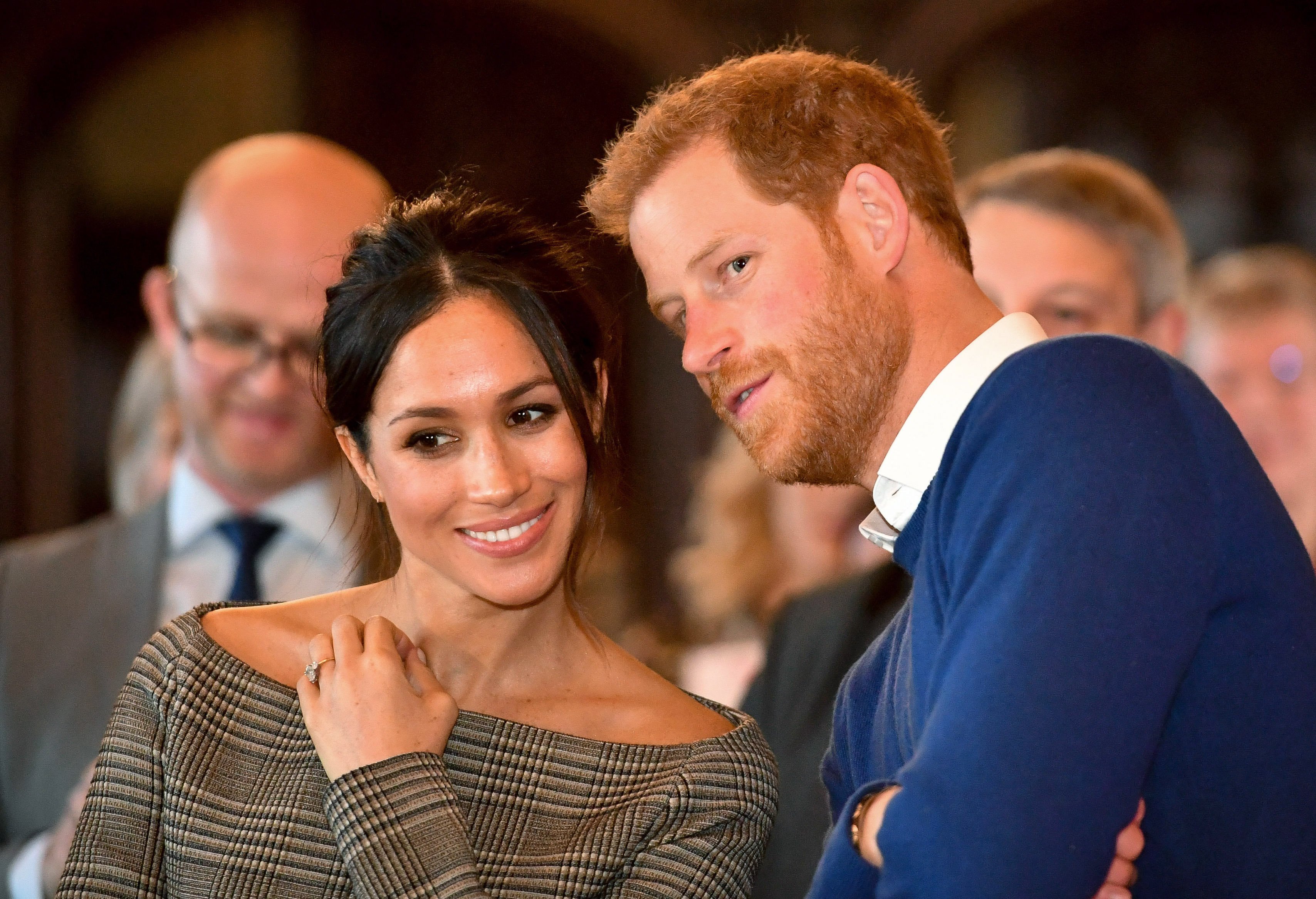 Prince Harry whispers to Meghan Markle as they watch a dance performance by Jukebox Collective in the banqueting hall during a visit to Cardiff Castle on January 18, 2018 in Cardiff, Wales | Source: Getty Images 