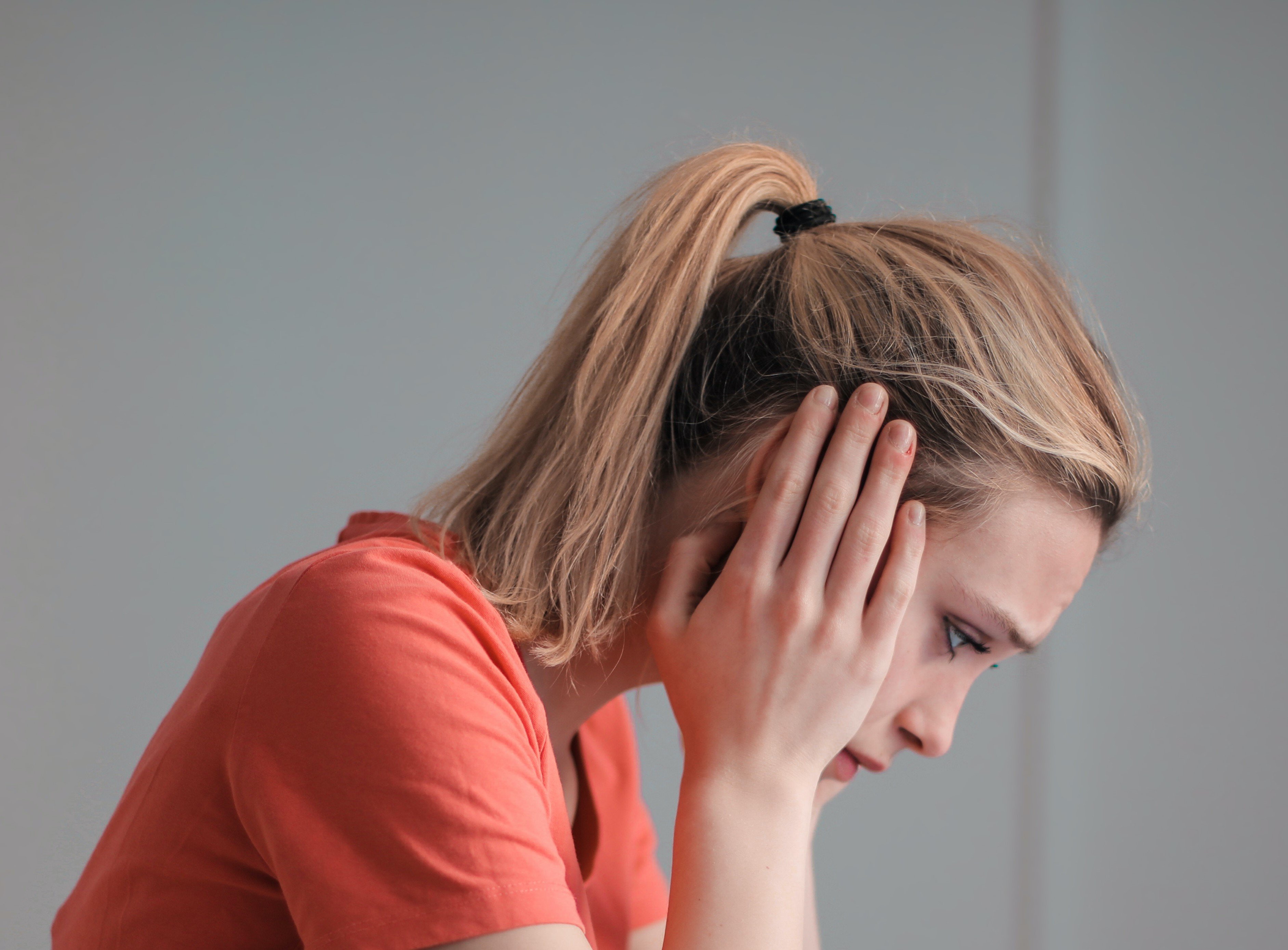 Una mujer cubriendo sus oídos con sus manos. | Foto: Pexels