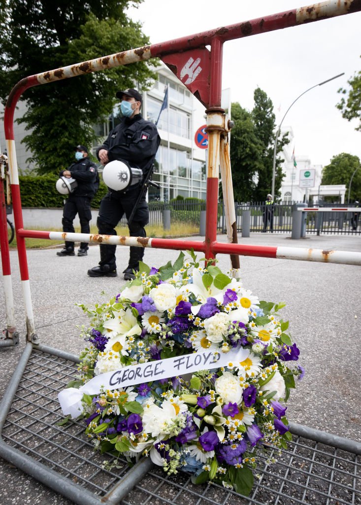 A wreath of flowers with the name "George Floyd" is leaning against a barrier at a demonstration against racism and police violence in front of the US Consulate | Photo: Getty Images