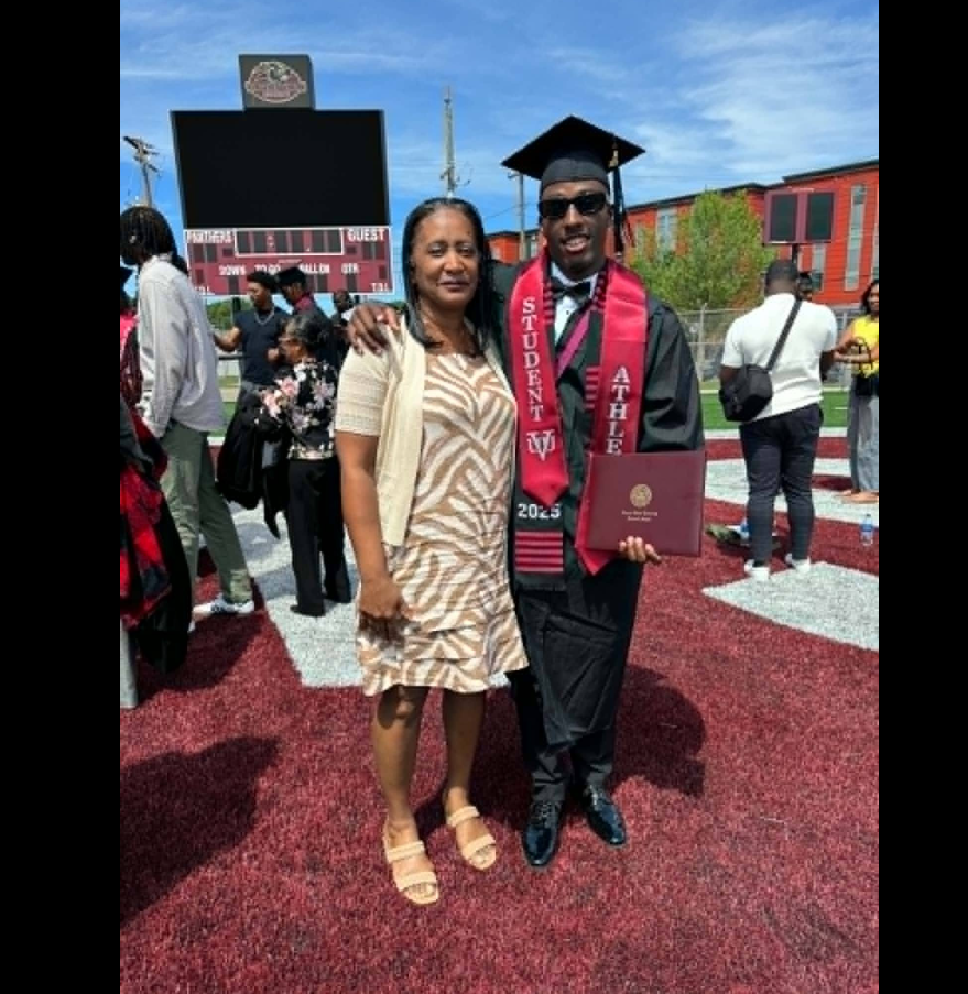 William Davis and his mother, Michelle Woodall, smile together on the field following graduation ceremonies. | Source: Facebook/Michelle Woodall