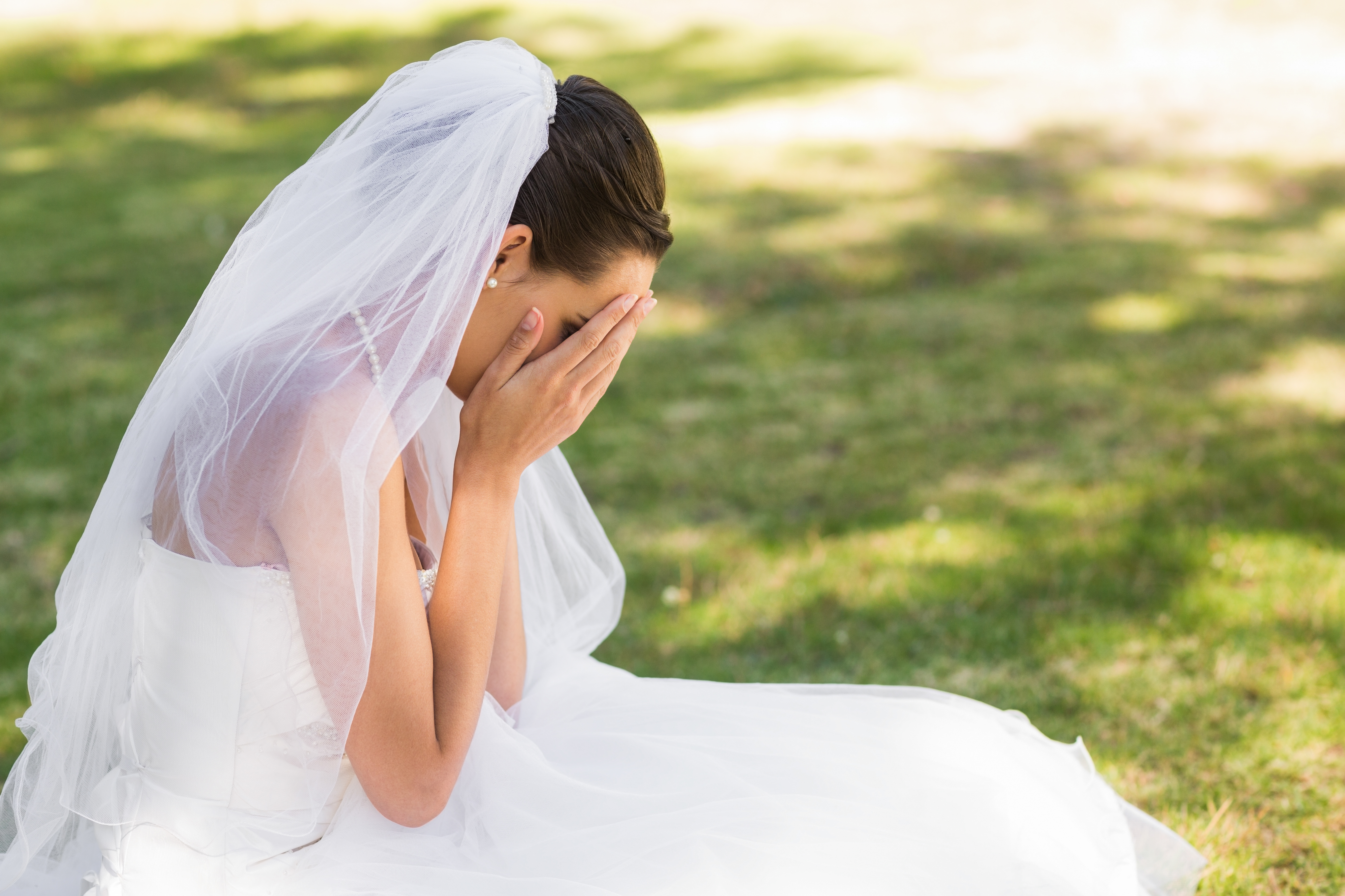 A bride crying while sitting on the ground | Source: Shutterstock
