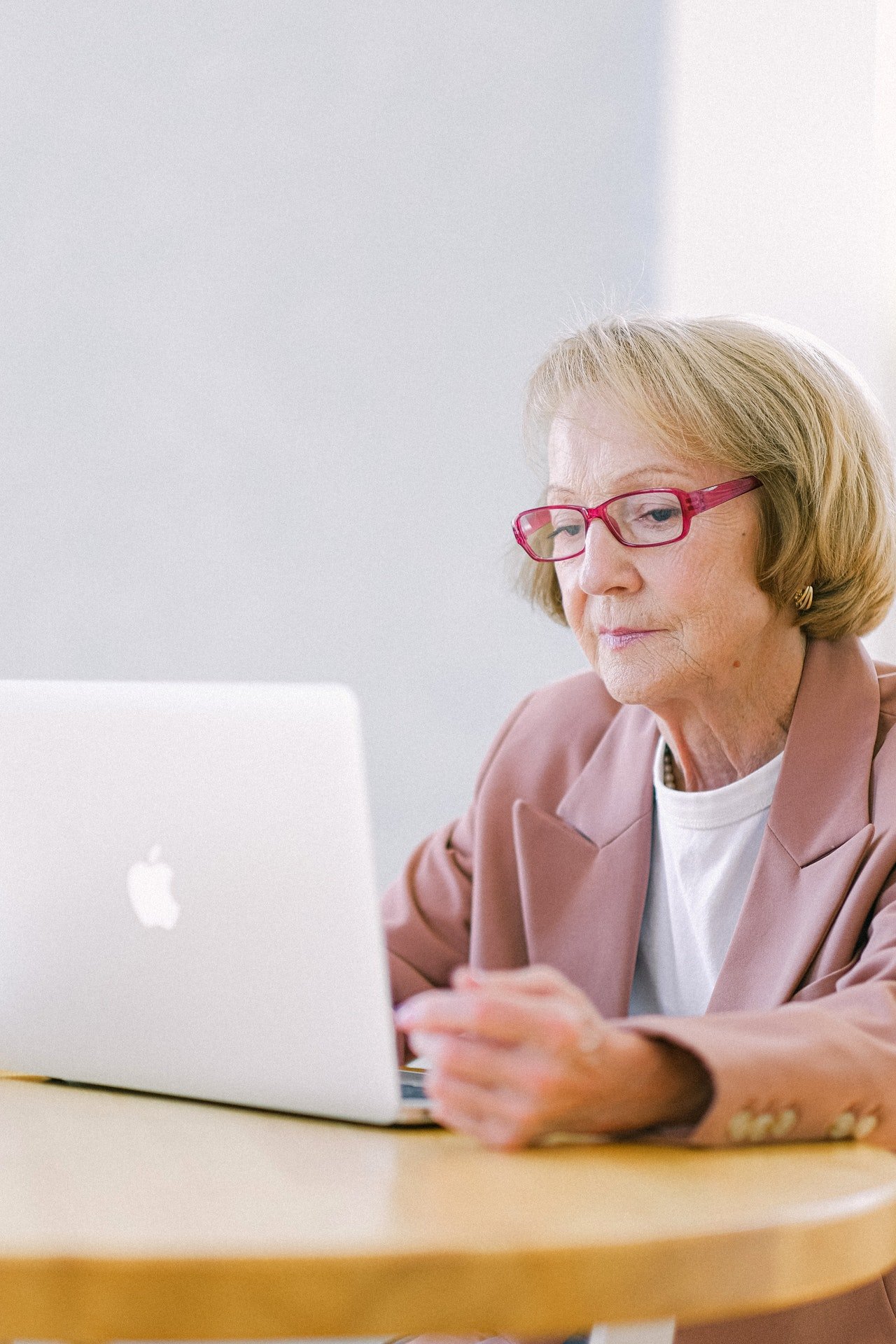 Una mujer mayor sentada frente a una computadora portátil. | Foto: Pexels