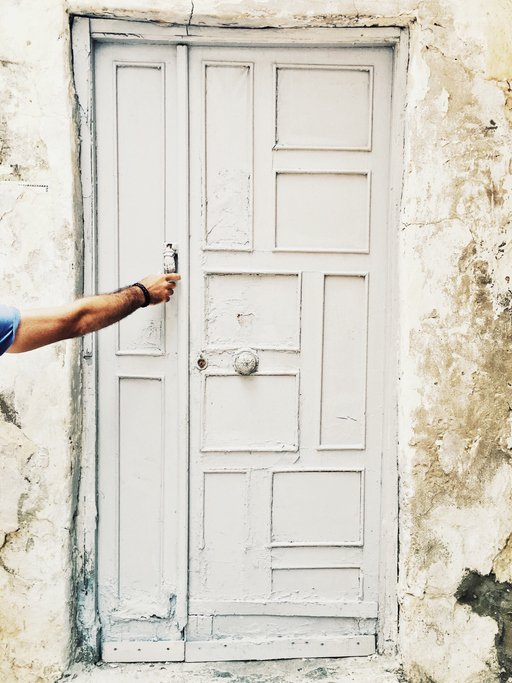 Una persona llama a la puerta deteriorada de un hogar. | Foto: Getty Images