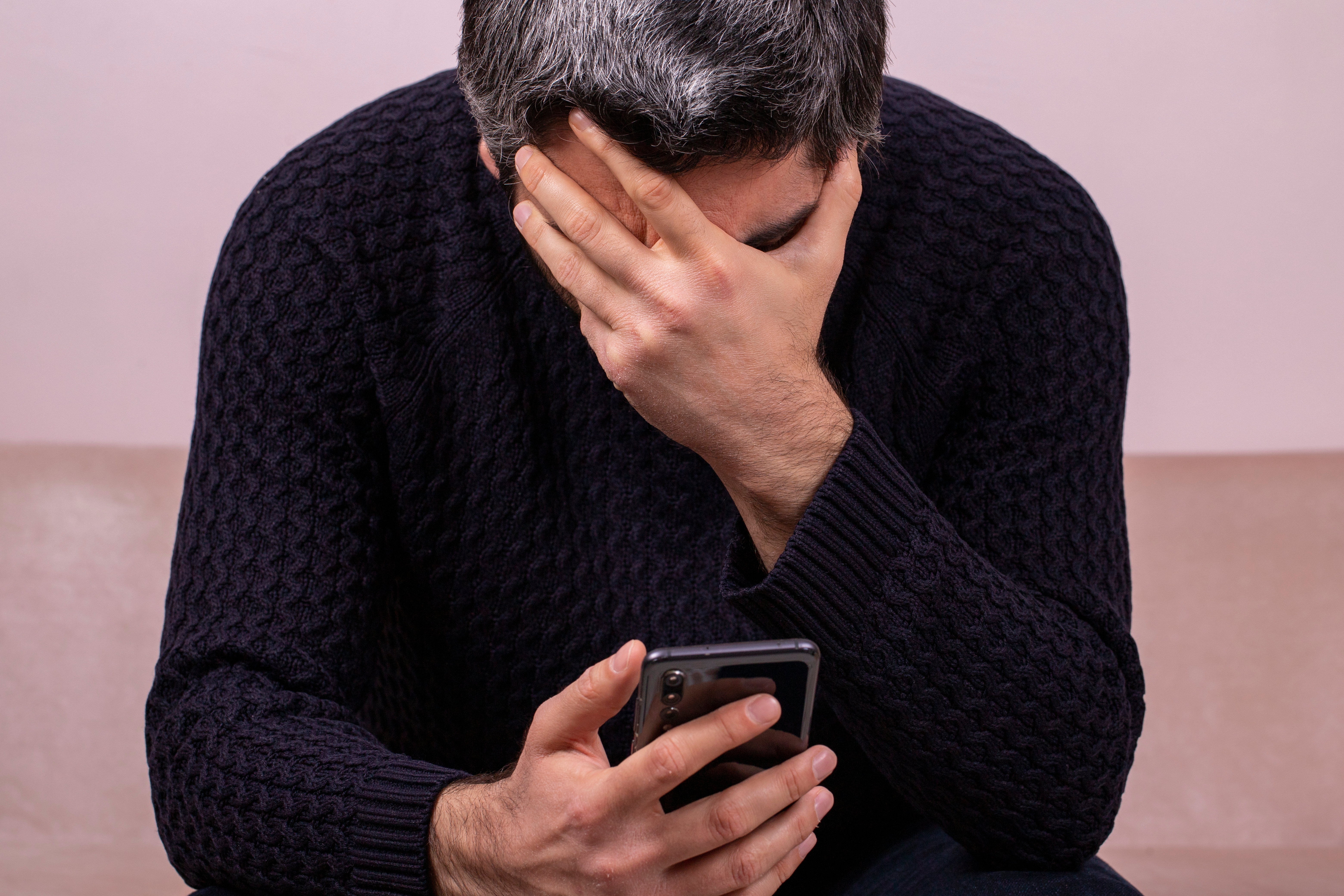 Sad middle-aged man with the phone in hand. | Source: Shutterstock