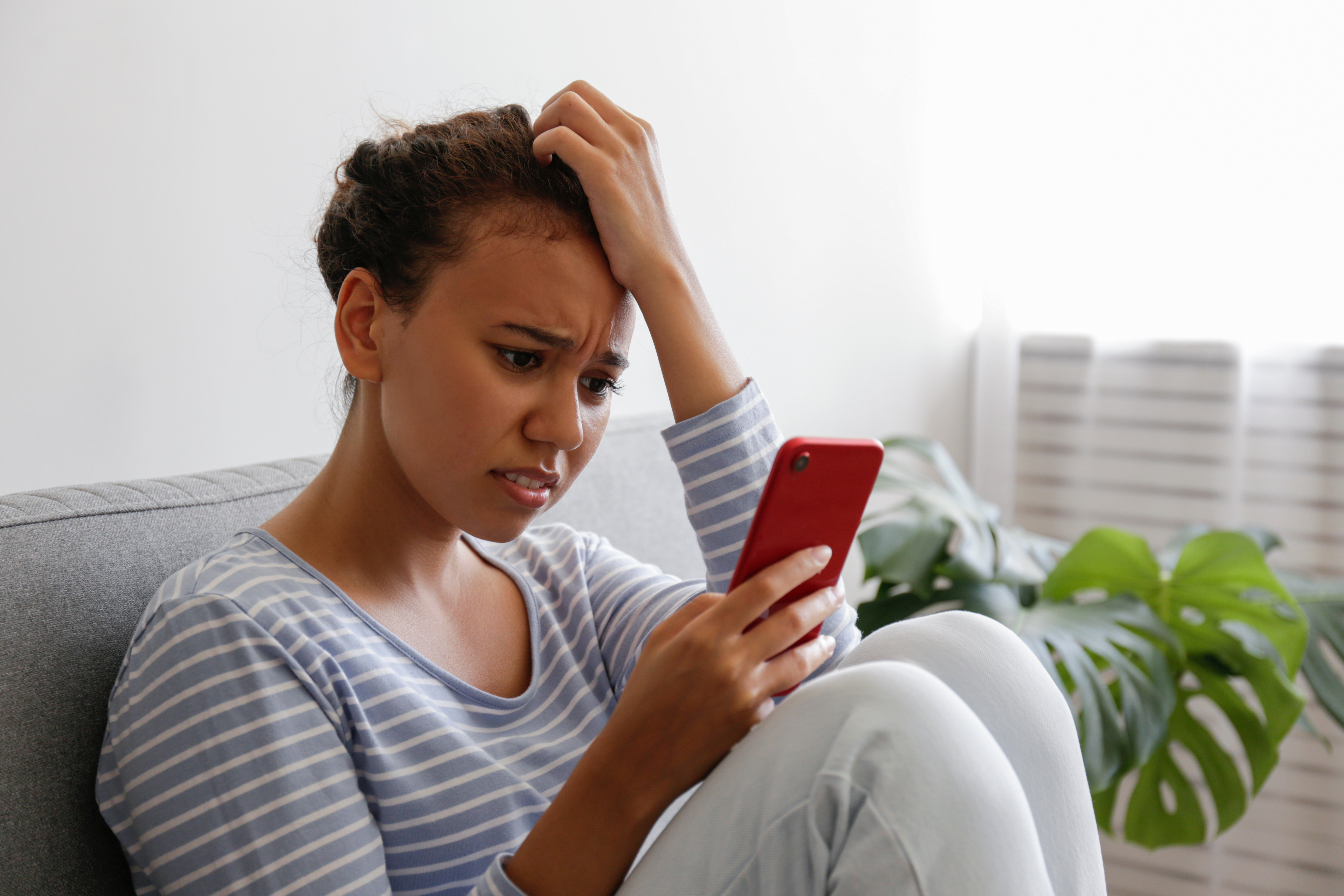 A woman worridly looking at her phone | Source: Shutterstock