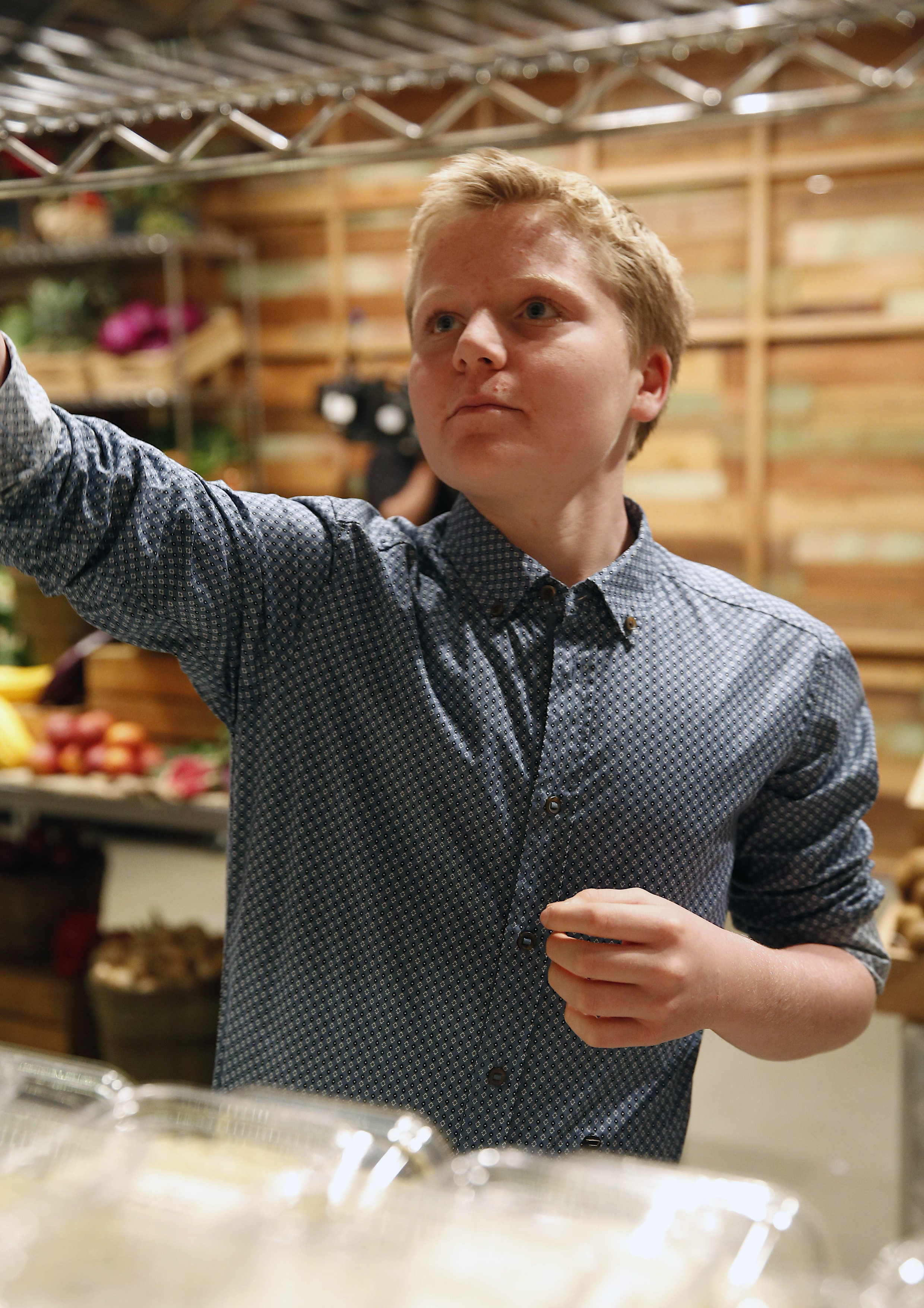 Jack Ramsay was captured mid-focus while selecting ingredients on the set of season four of "MasterChef" in 2013. Wearing the same patterned shirt as his father, he appeared calm and collected in the high-pressure environment, giving viewers a glimpse of his composed nature even in front of the cameras.