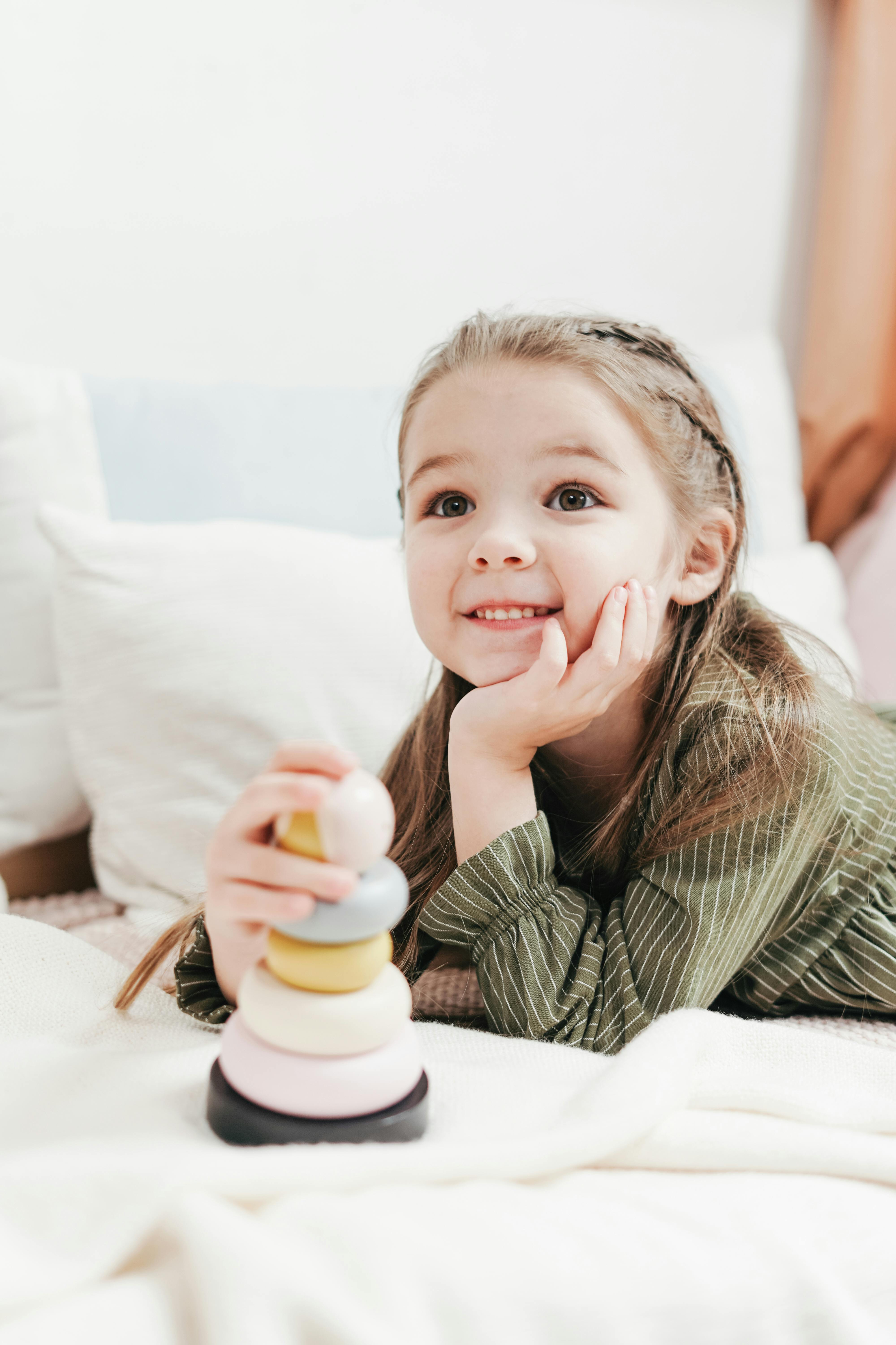 A little girl smiling while playing | Source: Pexels