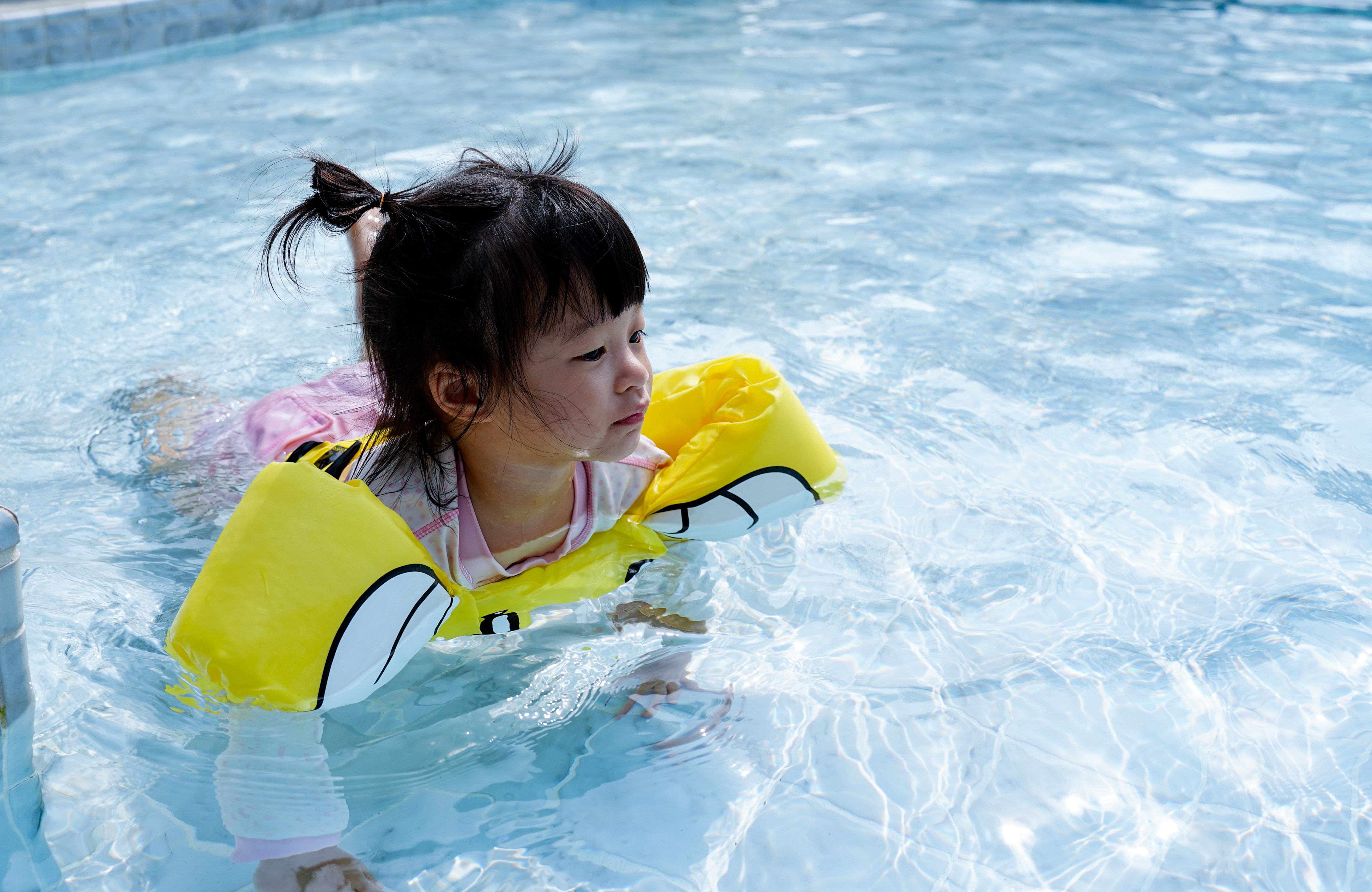Niña en piscina con chaleco salvavidas estilo "Puddle Jumpers". | Foto: Shutterstock