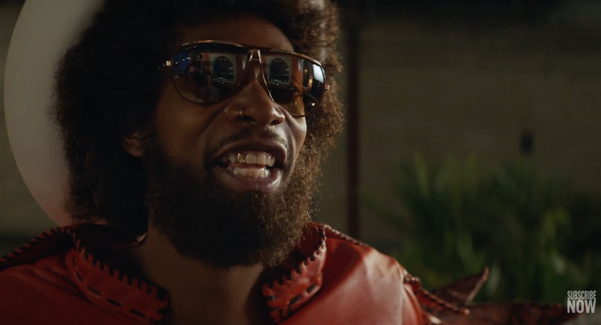 Wiz Khalifa portrays Parliament-Funkadelic founder George Clinton in a scene from the trailer for "Spinning Gold," shared in a video published on December 15, 2022. | Source: YouTube/E! News