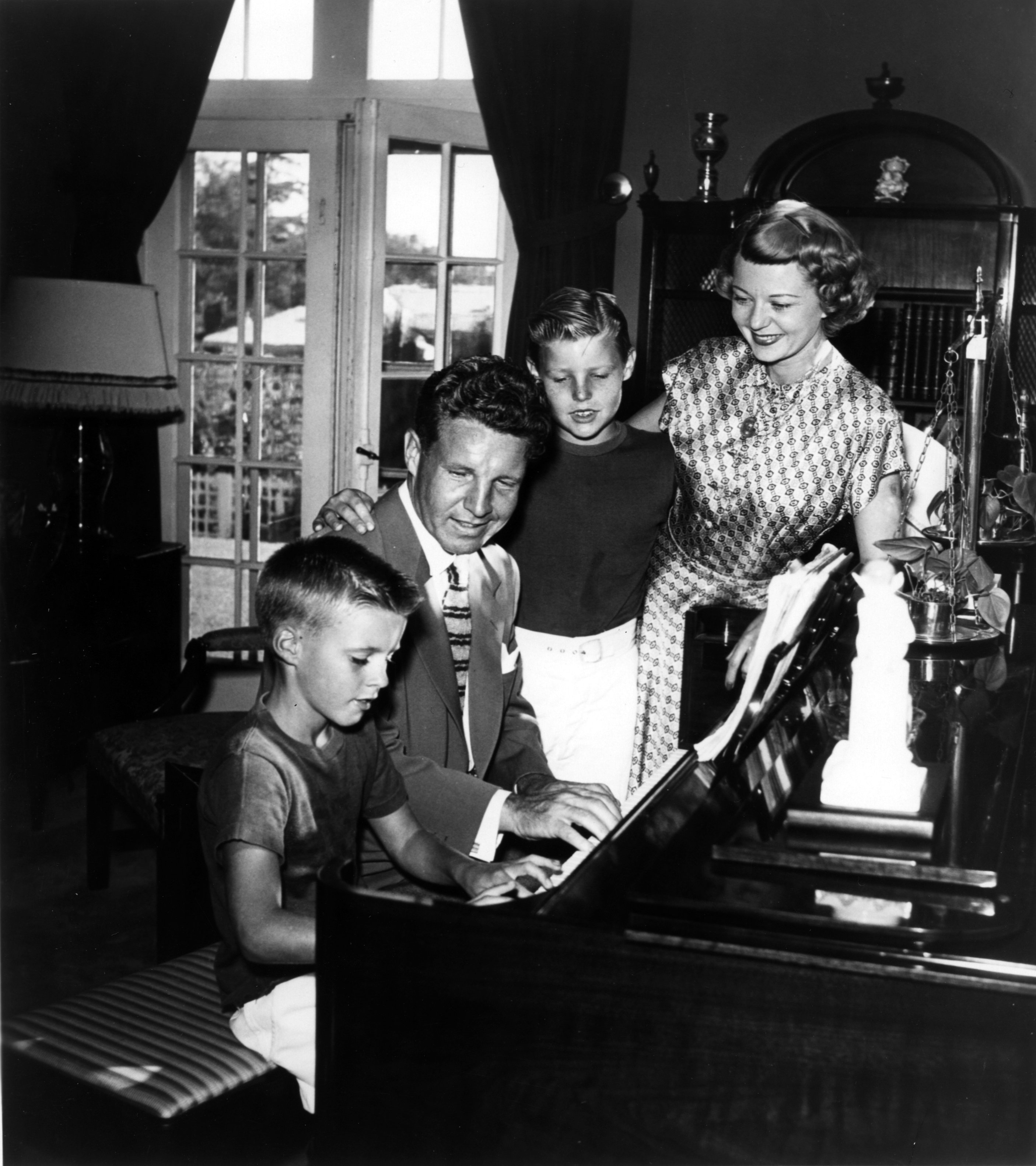 Ricky, Ozzie, David, and Harriet Nelson gather round the piano in circa 1946 in Los Angeles, California | Source: Getty Images