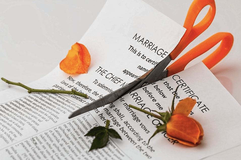 A photo of a scissors tearing through a marriage certificate | Photo: Pixabay