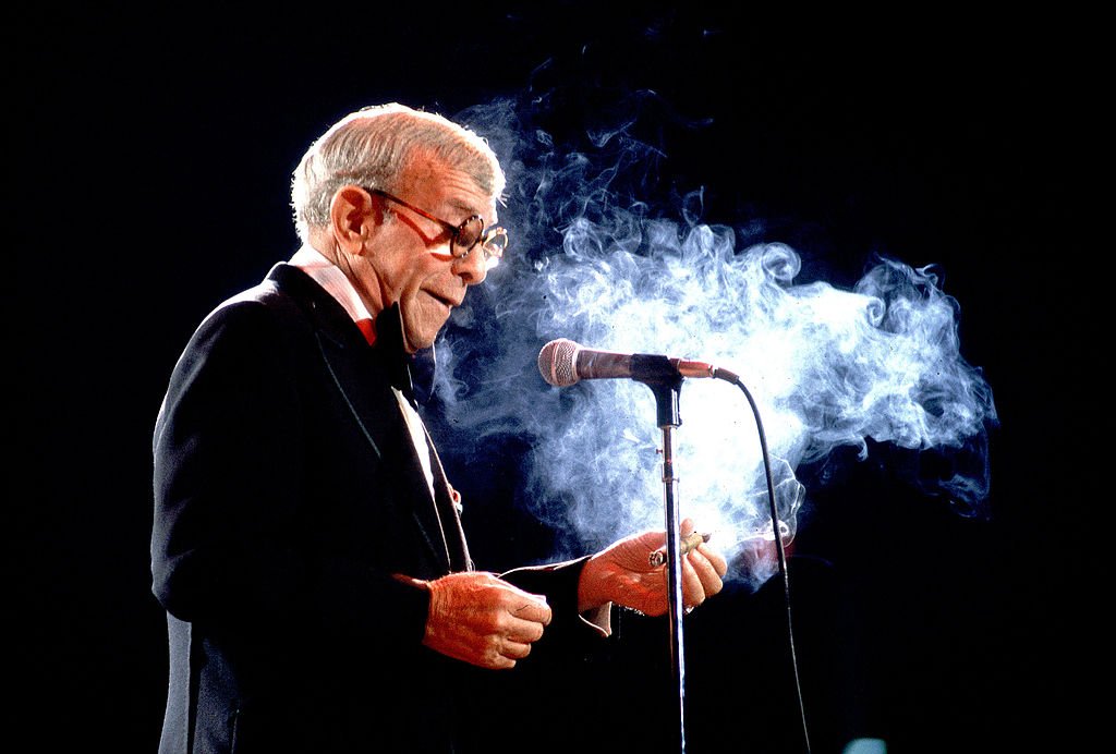 American comedian and actor George Burns (born Nathan Birnbaum, 1896 - 1996) smokes a cigar as he performs on stage, Chicago, Illinois, May 17, 1980. | Photo: Getty Images