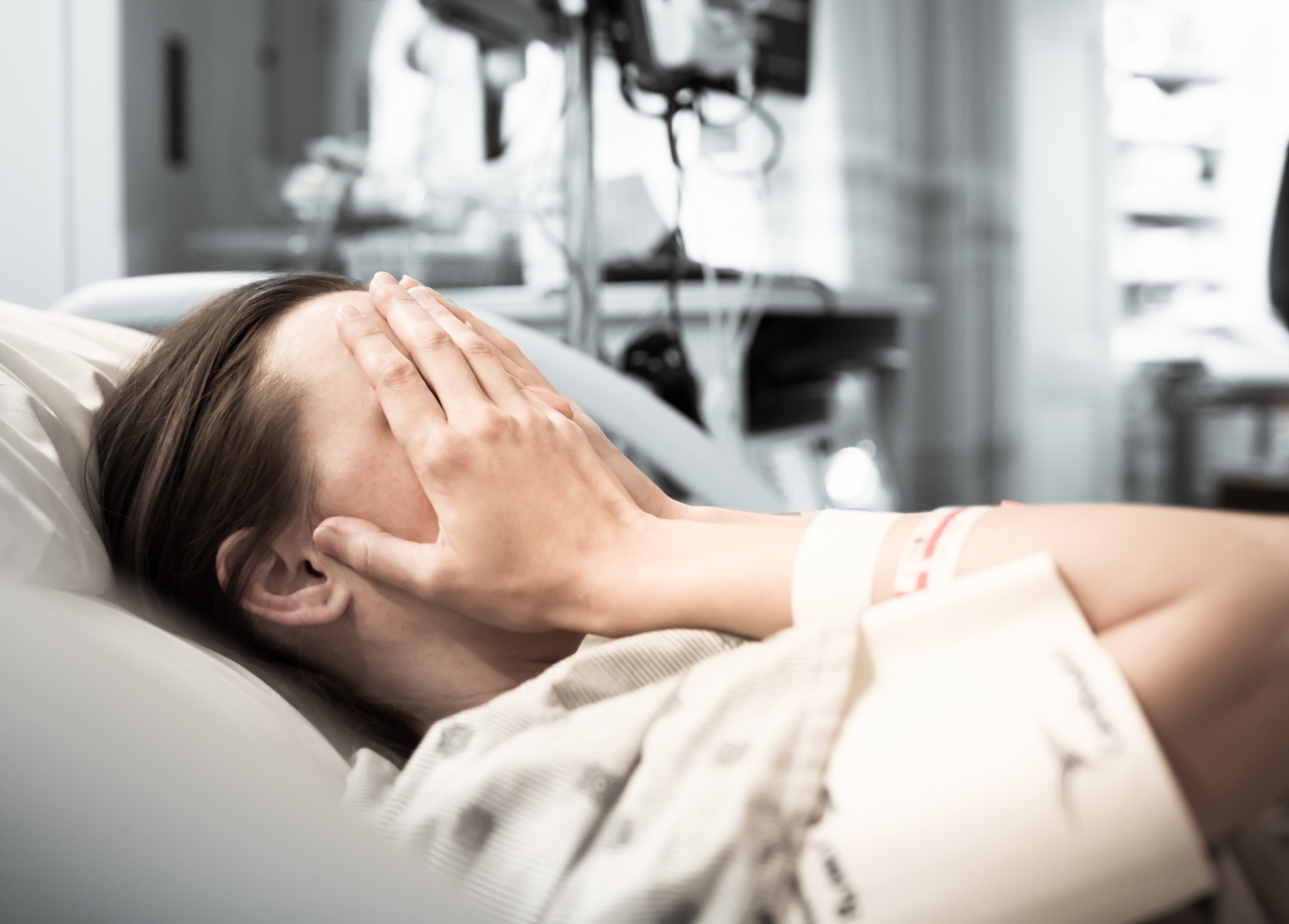 Mujer llorando en cama de hospital. | Foto: Shutterstock