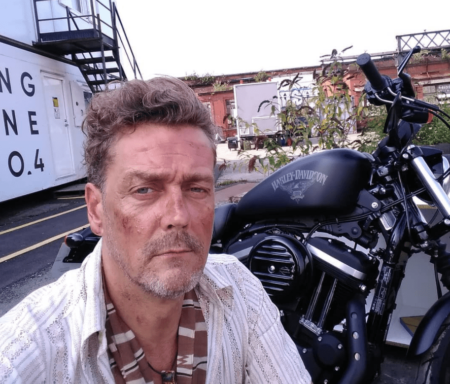 A screengrab of the late actor Toby Kirkup posing next to a black motorbike | Source: Instagram/@tobias.kirkup