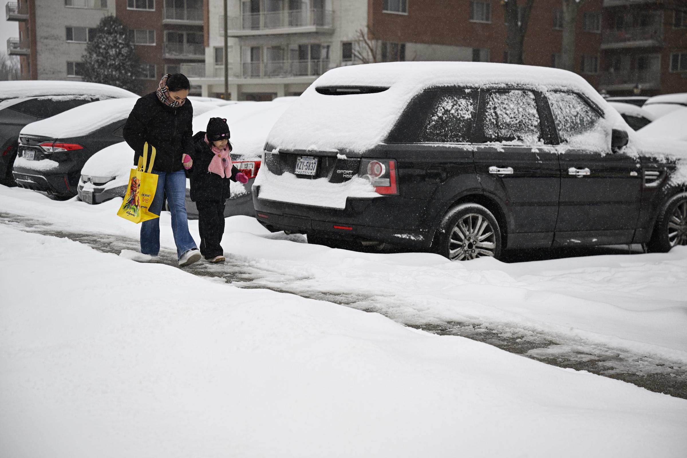 A woman and child carefully walk on an icy road | Source: Getty Images