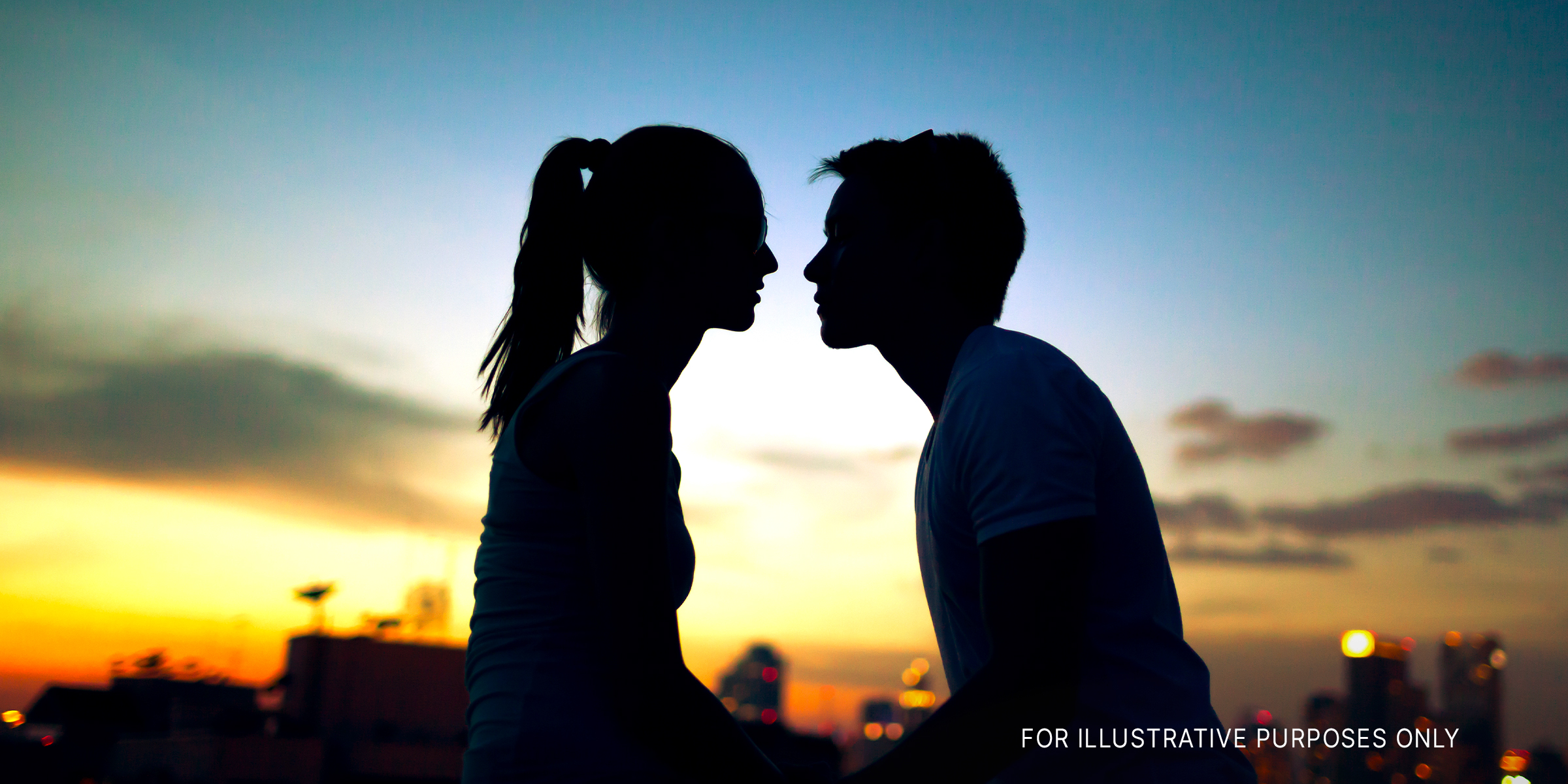 Silhouette photo of a young couple leaning in for a kiss during sunset. | Source: Shutterstock